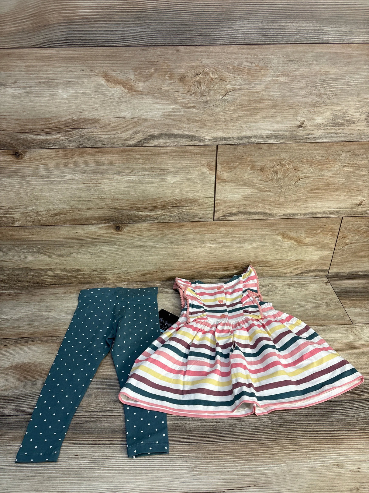 Girls' striped sleeveless dress with blue polka dot leggings on wood background