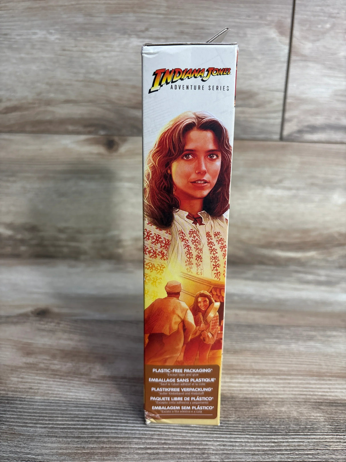Side view of Marion Ravenwood Indiana Jones action figure box showing portrait, market scene, and Plastic free packaging label