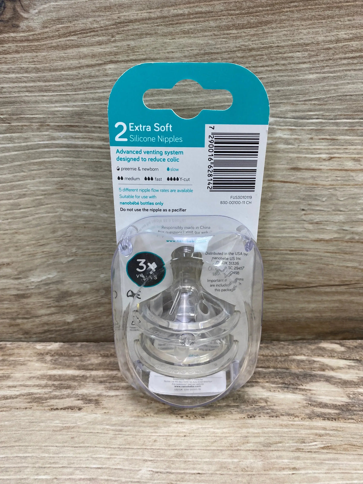 Front view of Nanobebe extra-soft slow-flow silicone nipples 2-pack in clear blister pack on wood background
