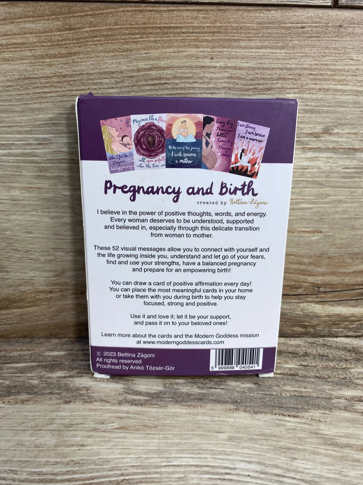 Back view of Pregnancy and Birth affirmation cards box showing descriptive text and barcode on purple and white box with wood background