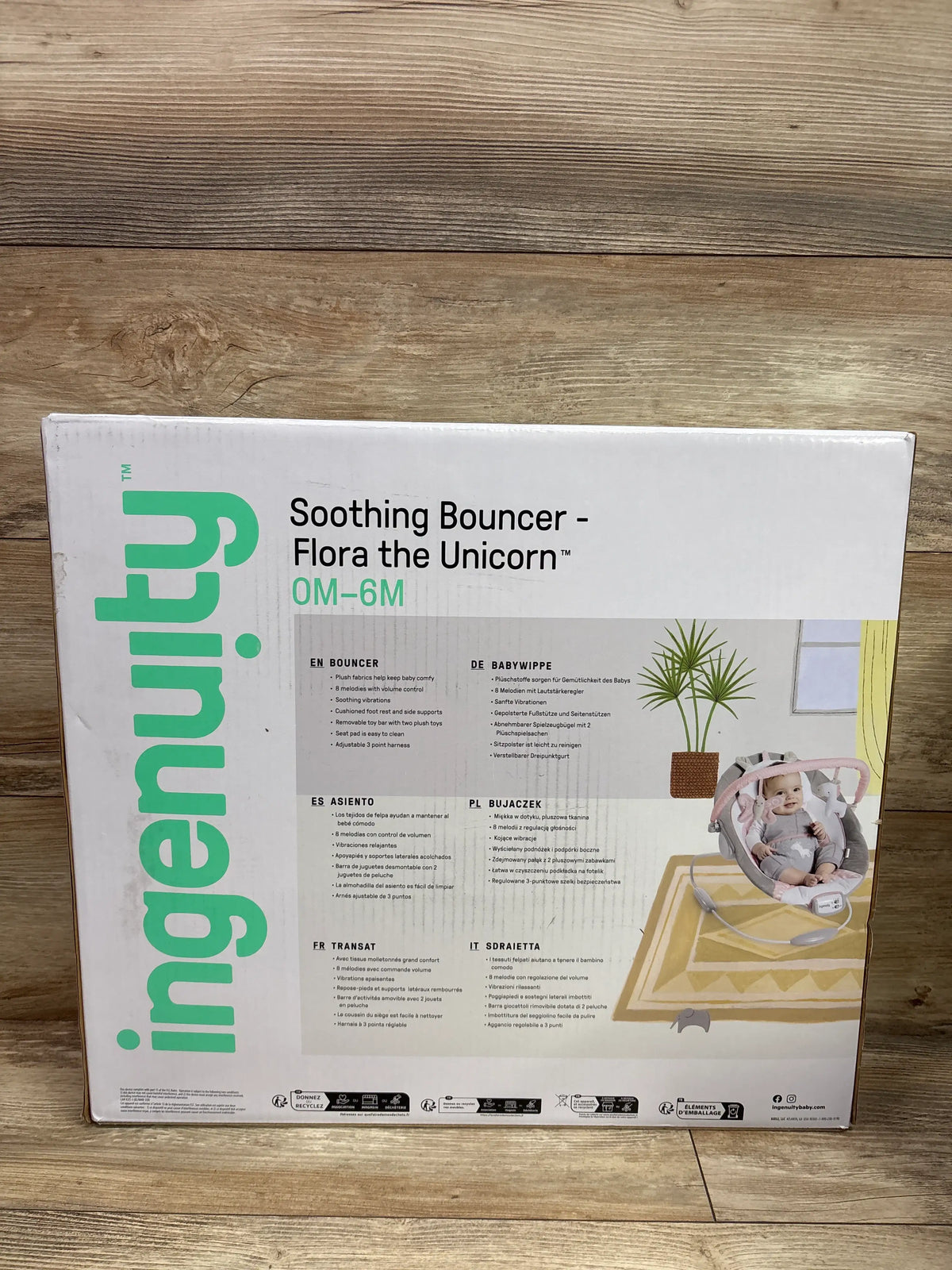 Front of Ingenuity Soothing Bouncer Flora the Unicorn box showing a baby in the bouncer for ages 0 to 6 months