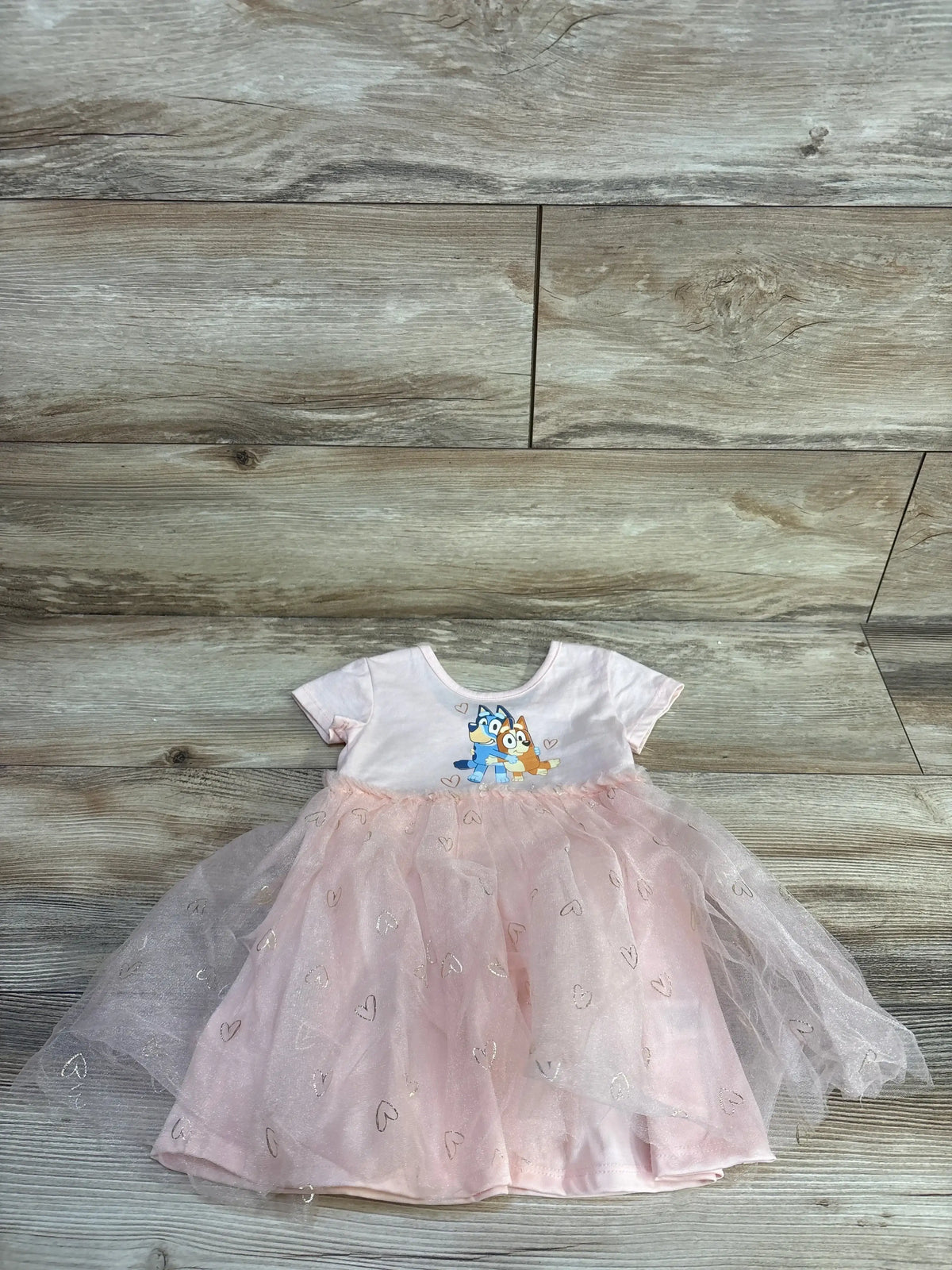 Front view of Bluey tulle toddler dress, pink size 18 months, showing layered tulle skirt and Bluey character on bodice on white background