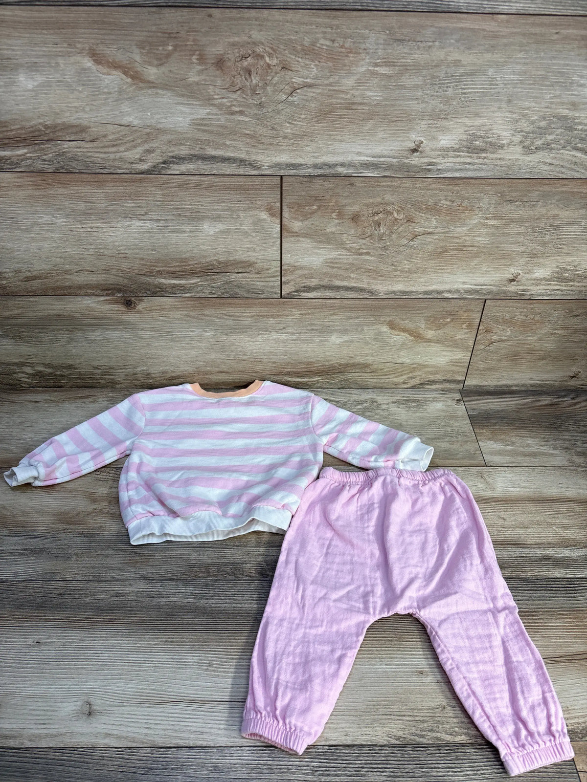 Top view of pink Old Navy sweatshirt and joggers set showcasing striped sweatshirt and matching joggers on a wood background