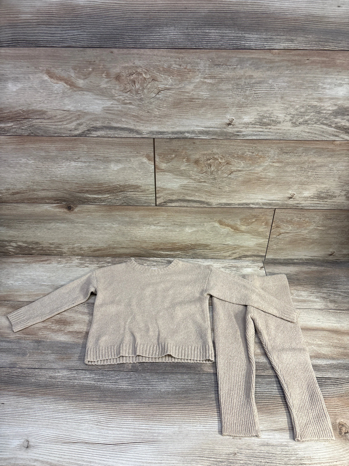 Flat lay of tan Cat and Jack knit sweater and ribbed pants showing ribbed texture, size 18m, on wood background