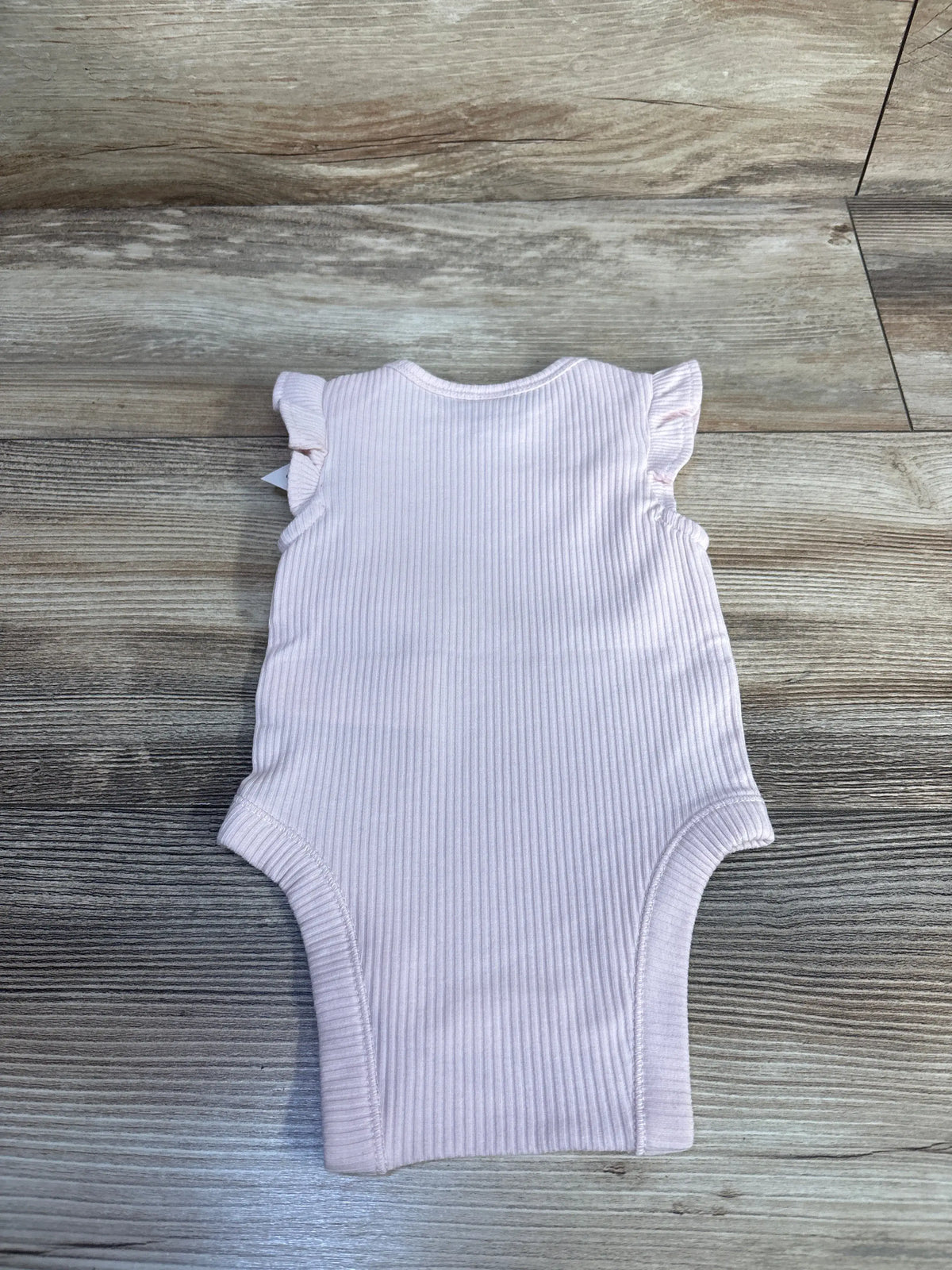 Baby Gap ribbed pink flutter sleeve bodysuit for infants size 0-3m on a wooden background