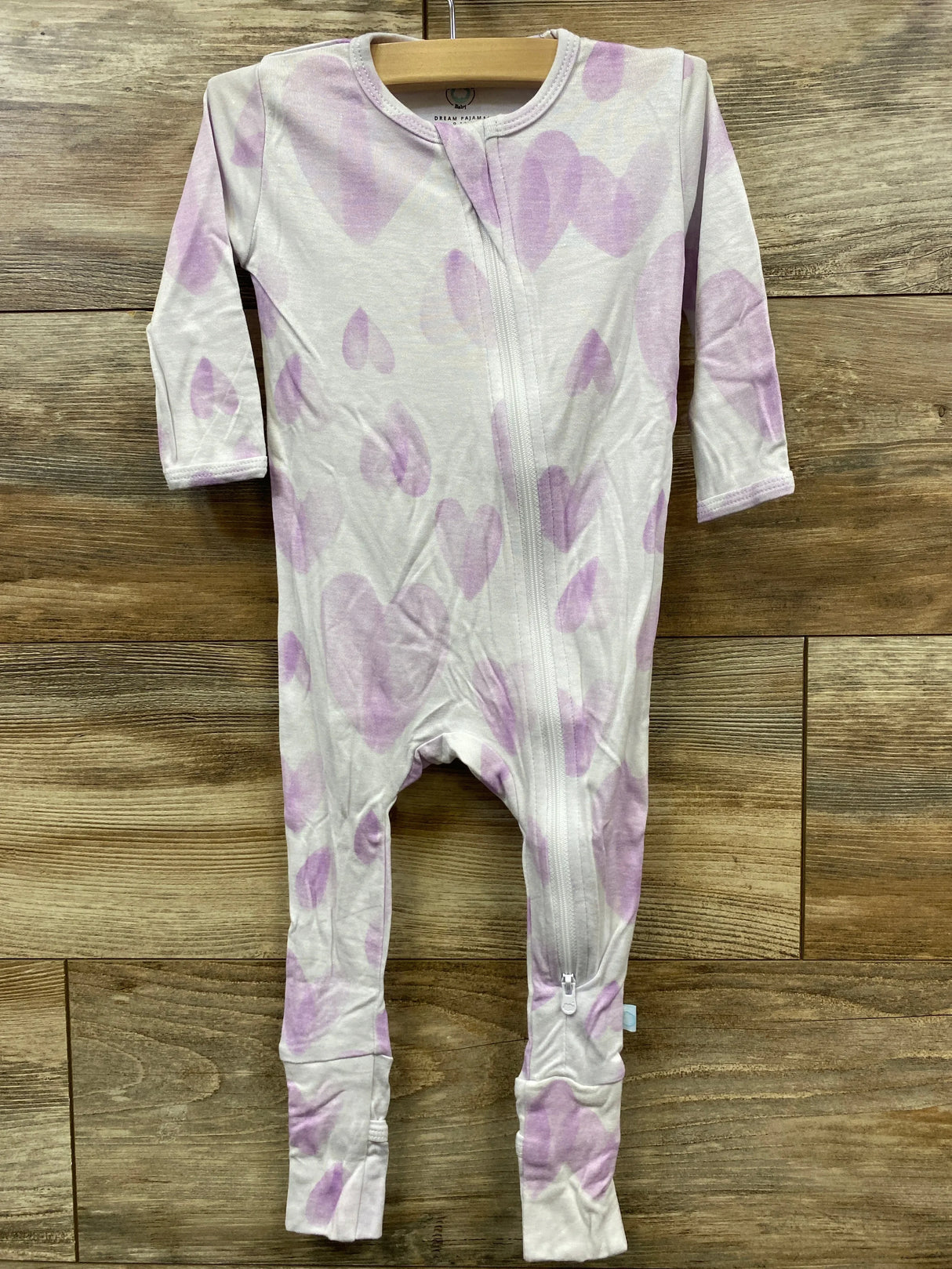 Light purple heart print baby sleeper with zipper on wooden background