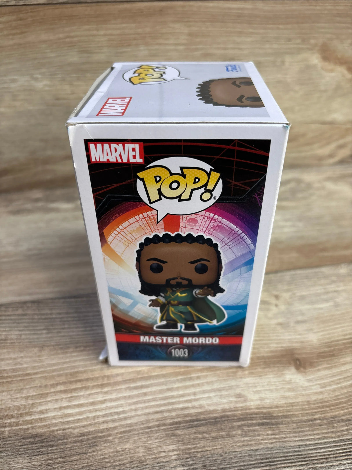 Front view of Funko Pop Master Mordo box showing front art with Marvel and POP logos and number 1003 on wood tabletop