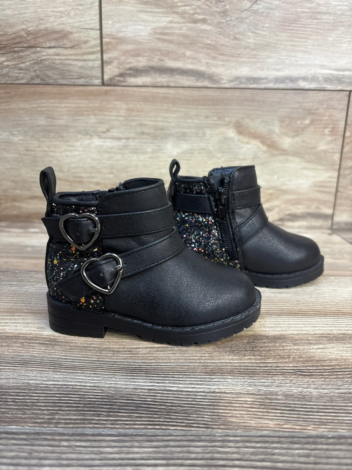 Black toddler boots with glitter sides, heart buckles, and side zipper for easy wear.