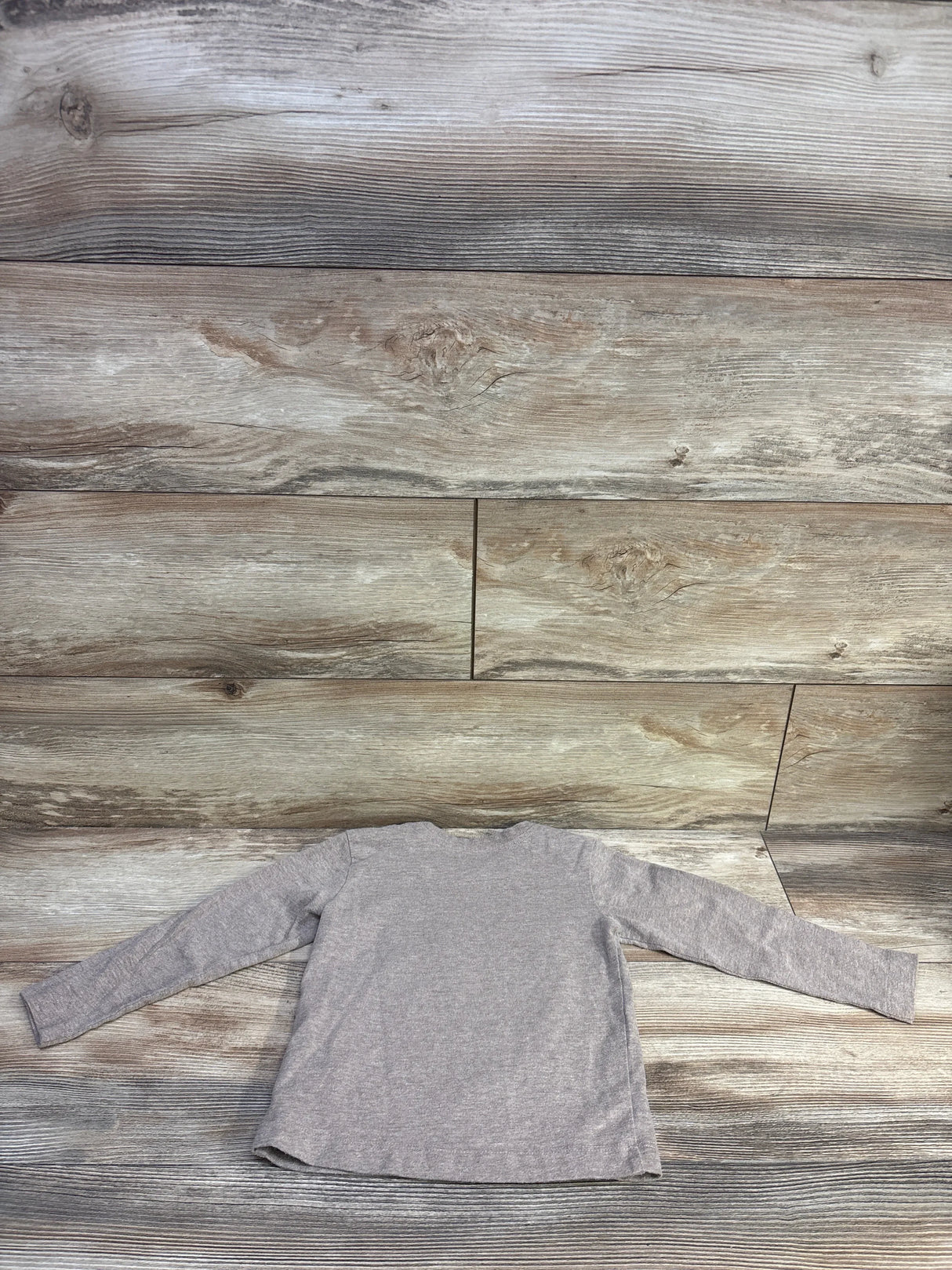 Back flat-lay of Pekkle toddler long-sleeve brown heather shirt showing long sleeves and curved hem on wood plank background