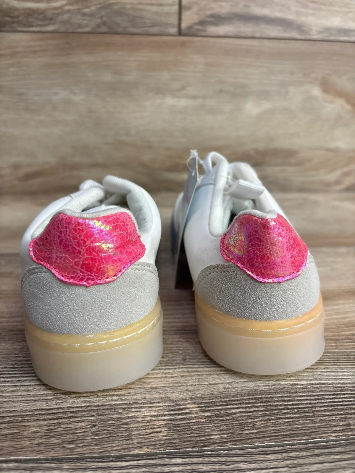 Kids sneakers with iridescent pink heel detail and white suede, viewed from the back