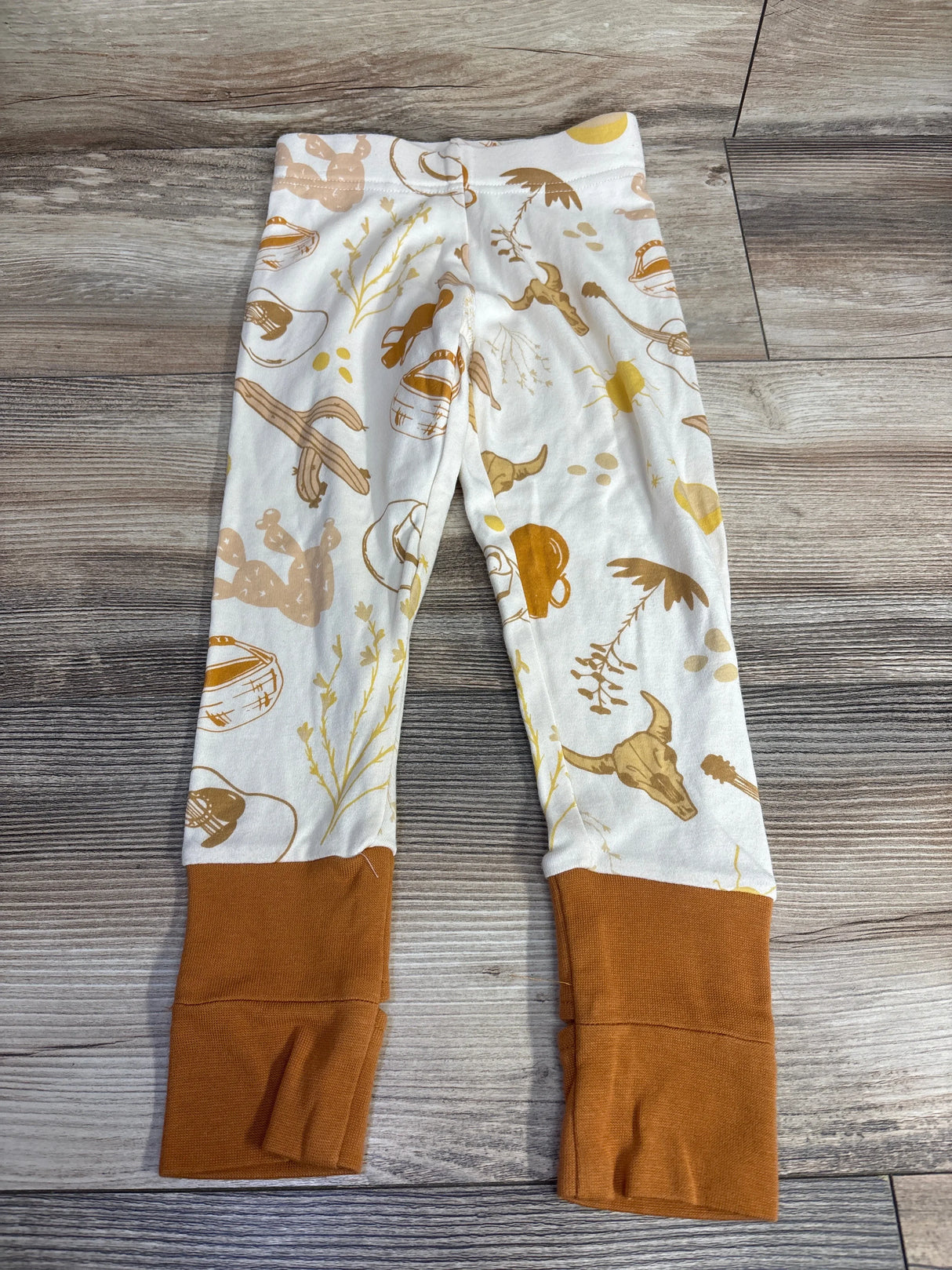 Kids leggings with western print and brown cuffs on wooden floor