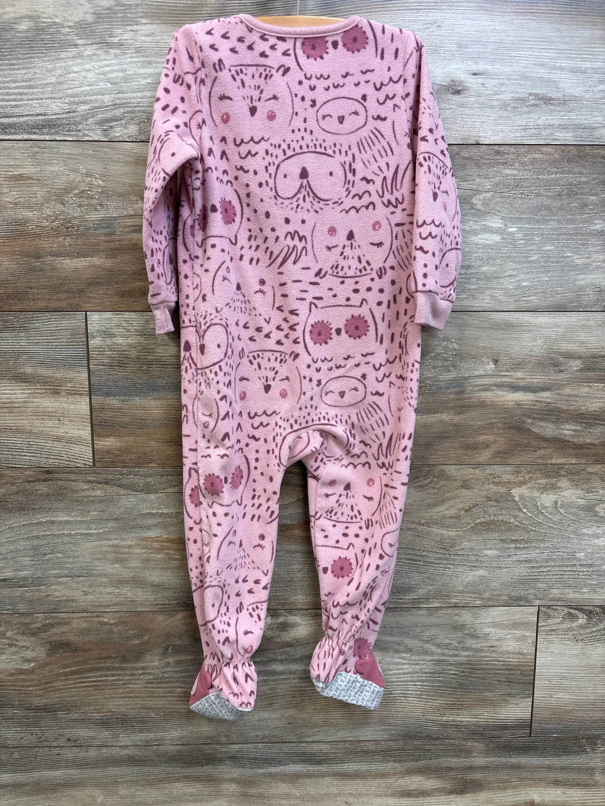 Front view of Carters pink owl print blanket sleeper in size 2T showcasing long sleeves and footed legs on a wood-grain background