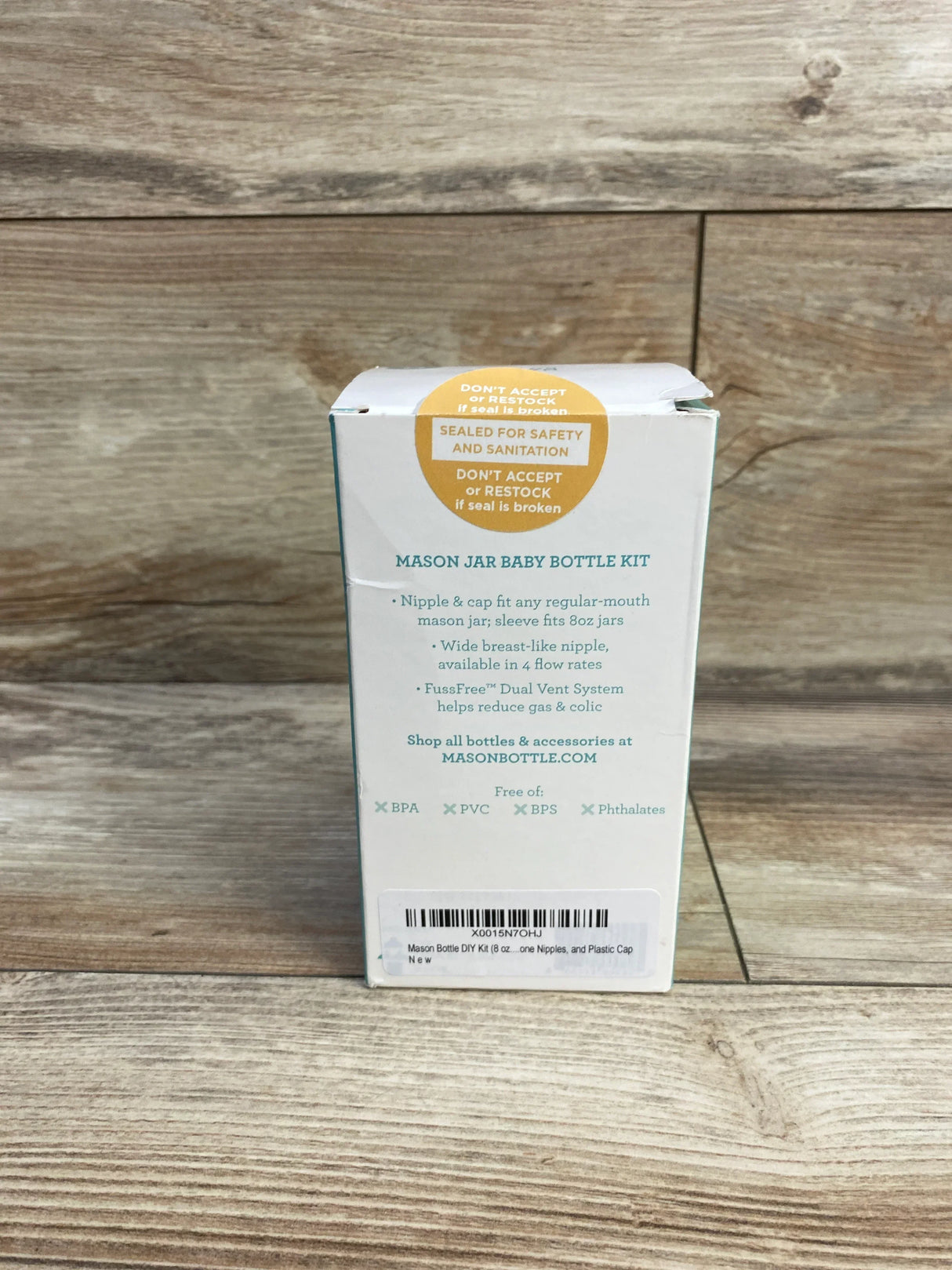 Mason jar baby bottle kit box with product details on wood background, BPA free, anti-colic design.