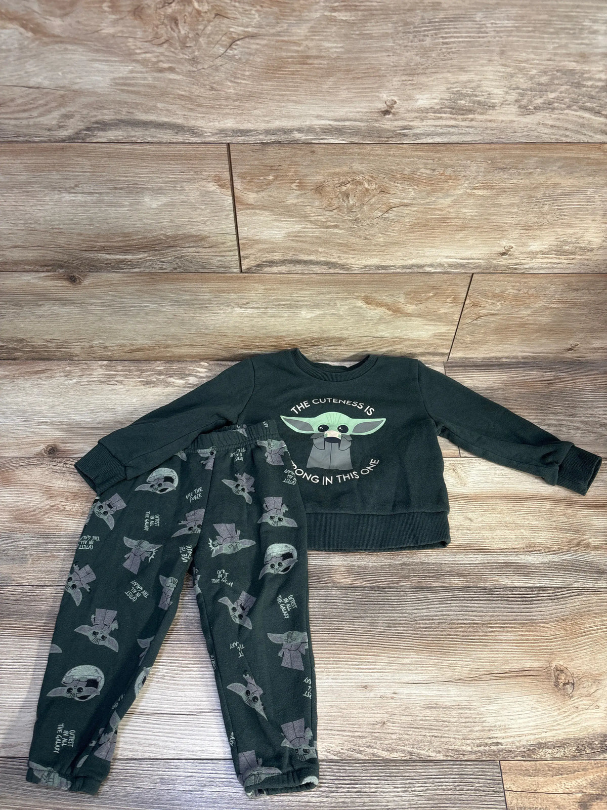 Flat lay of green Star Wars Yoda sweatshirt and joggers set showcasing matching graphics and sweatshirt text on wood flooring