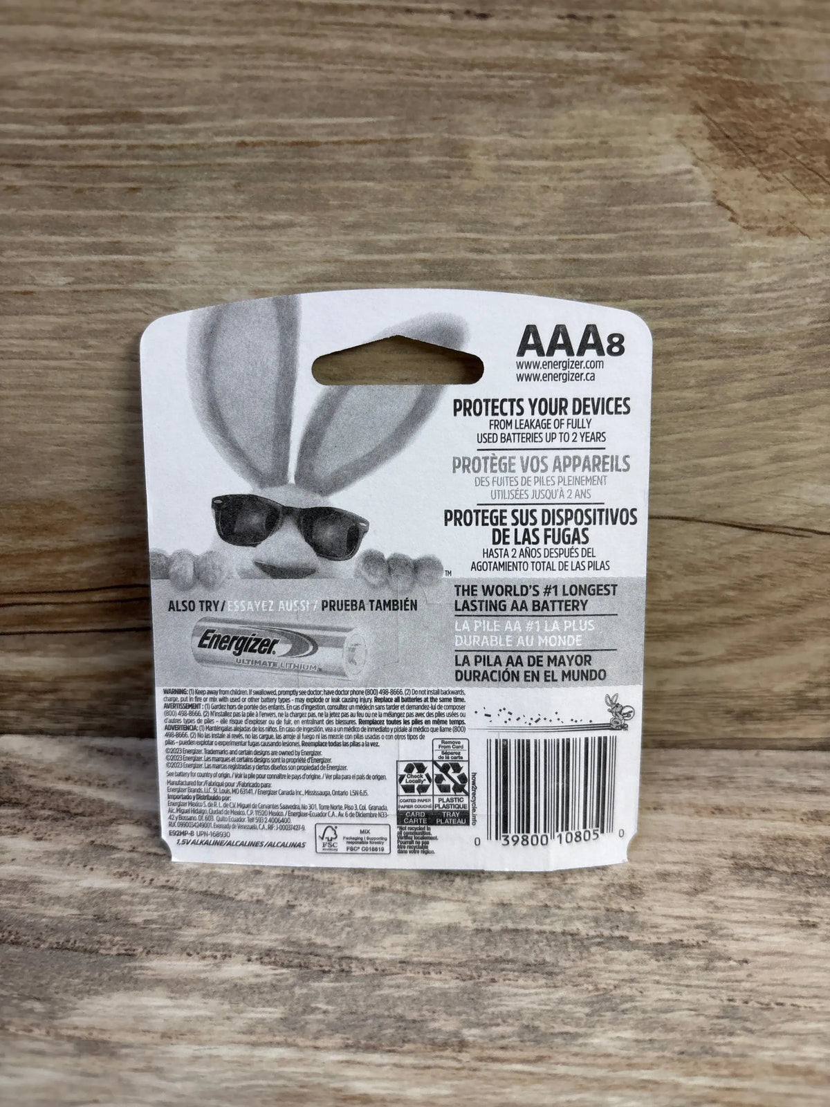 Back view of Energizer Max AAA 8 pack packaging showing leakage protection claim, barcode, and product details on a wood background