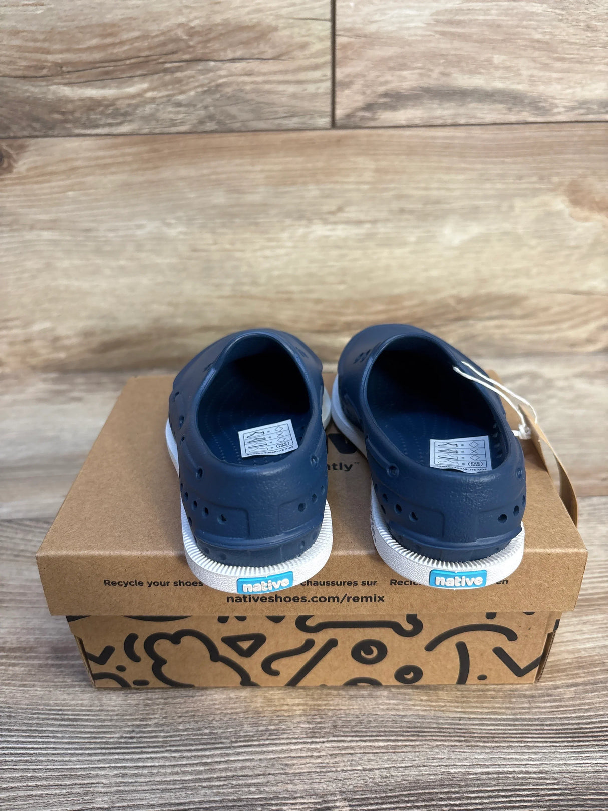 Rear view of Native Howard Sugarlite navy toddler slip-on shoes showing white soles and heel logo on recycled shoebox