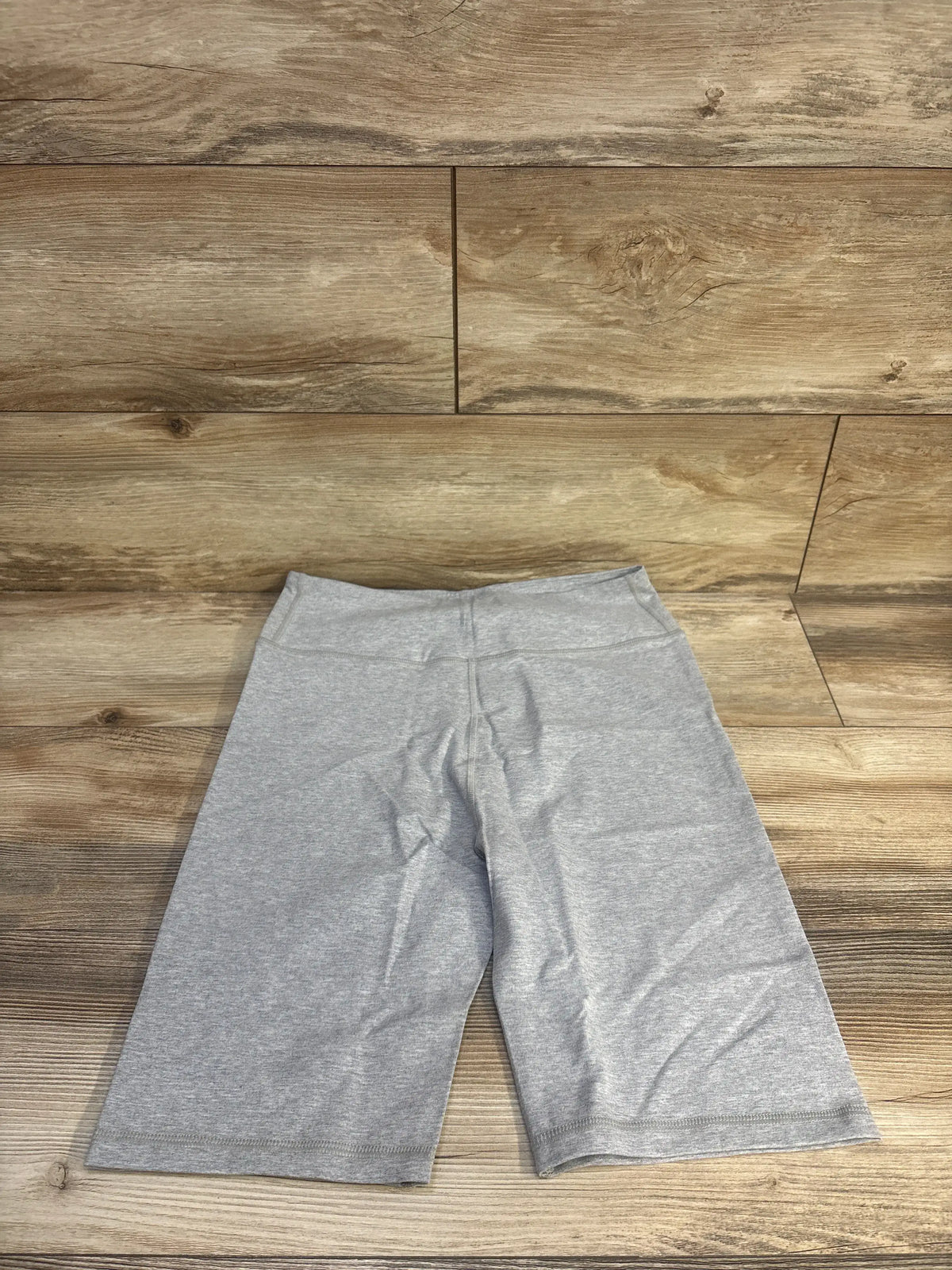 Front view of gray Gap maternity bike shorts in size small showcasing a smooth wide waistband on a wood floor