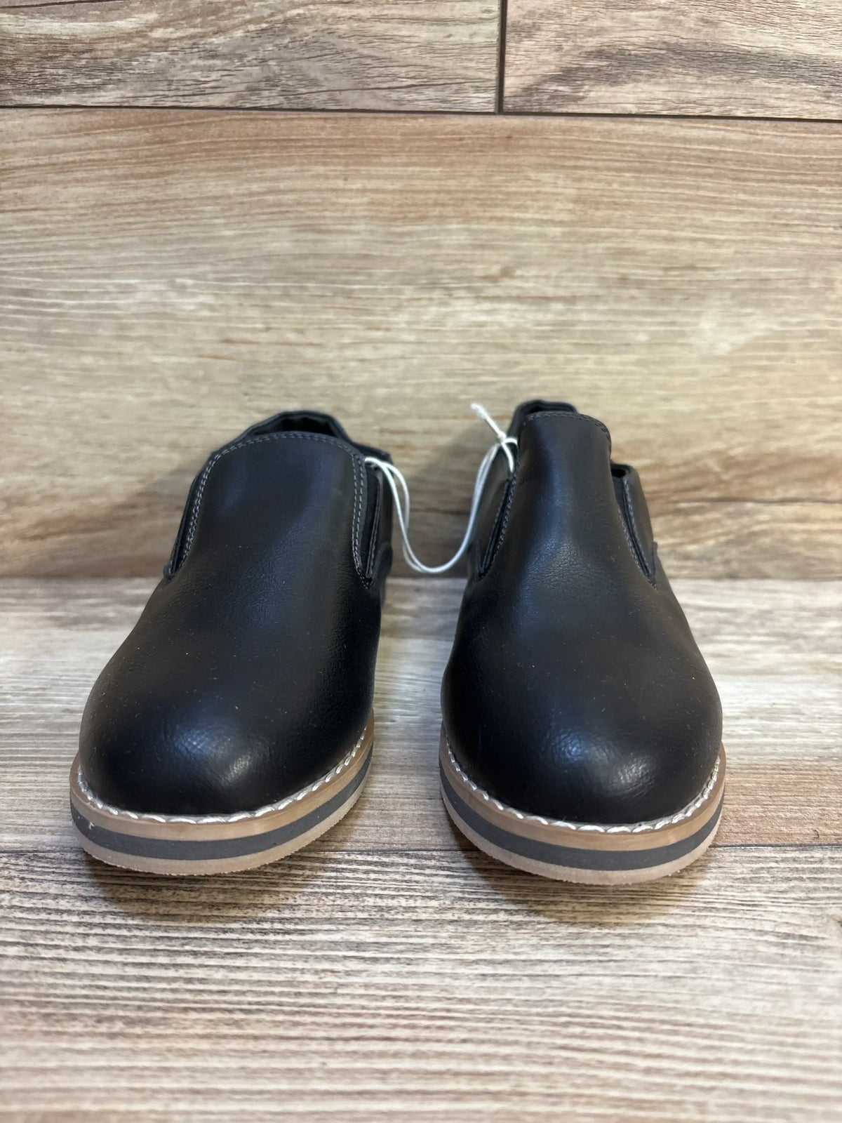Front view of Cat & Jack Neal black children’s loafers showcasing slip-on elastic sides and tan layered soles on wood background