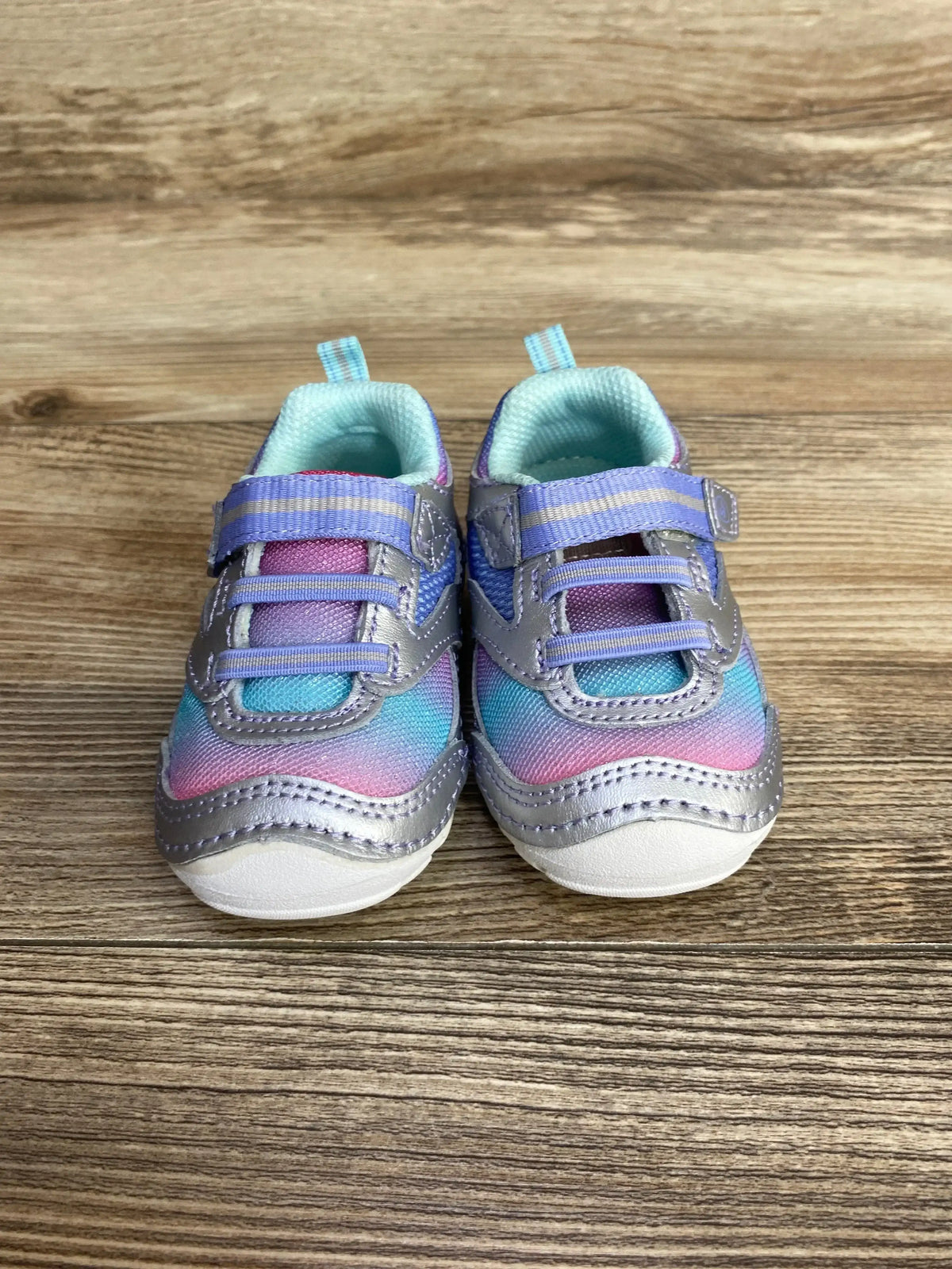 Colorful toddler sneakers with Velcro straps on wood background, kids shoes resale