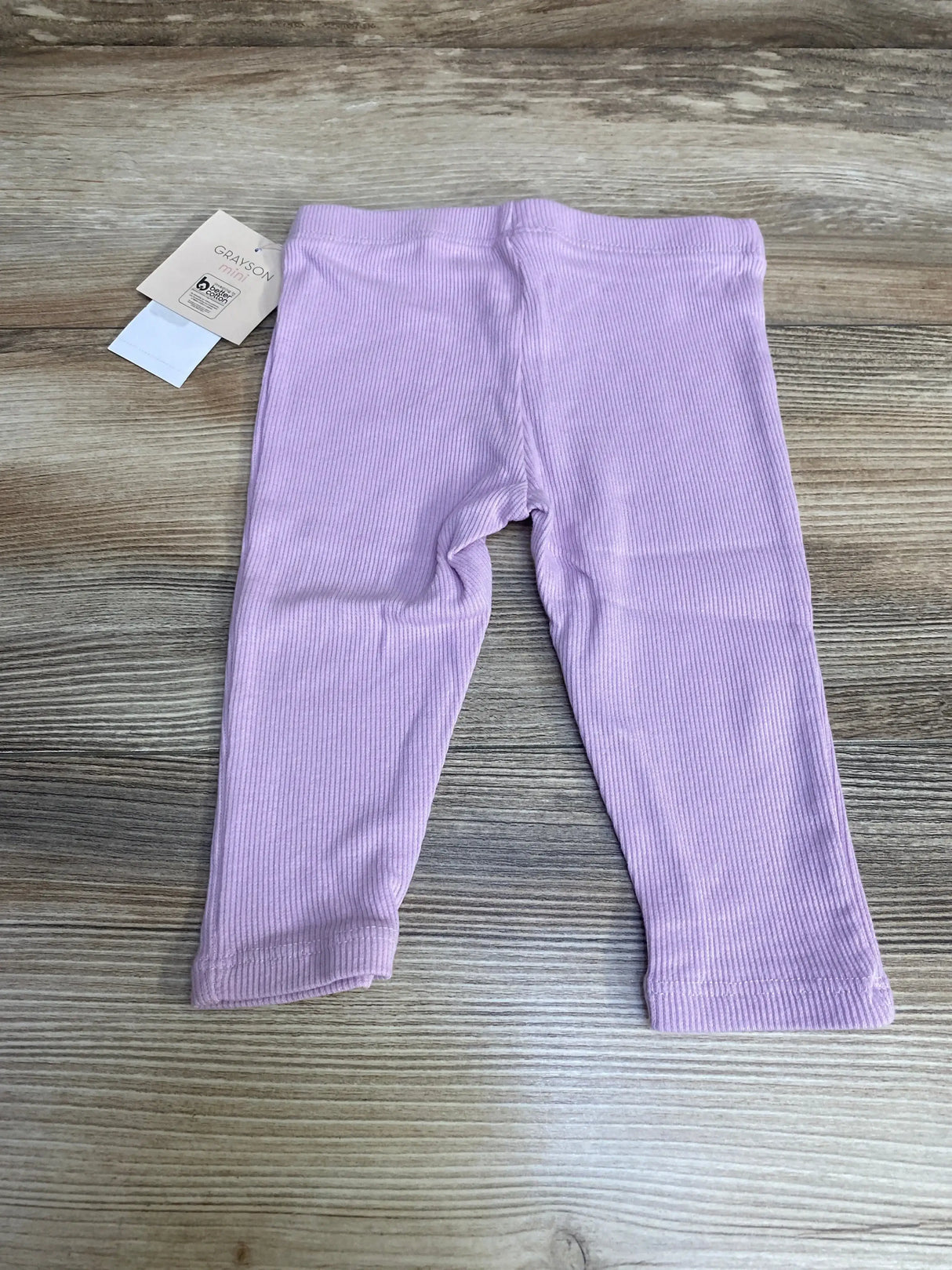 Flat lay of Grayson mini ribbed leggings showing ribbed texture and elastic waistband in light purple on wood floor background