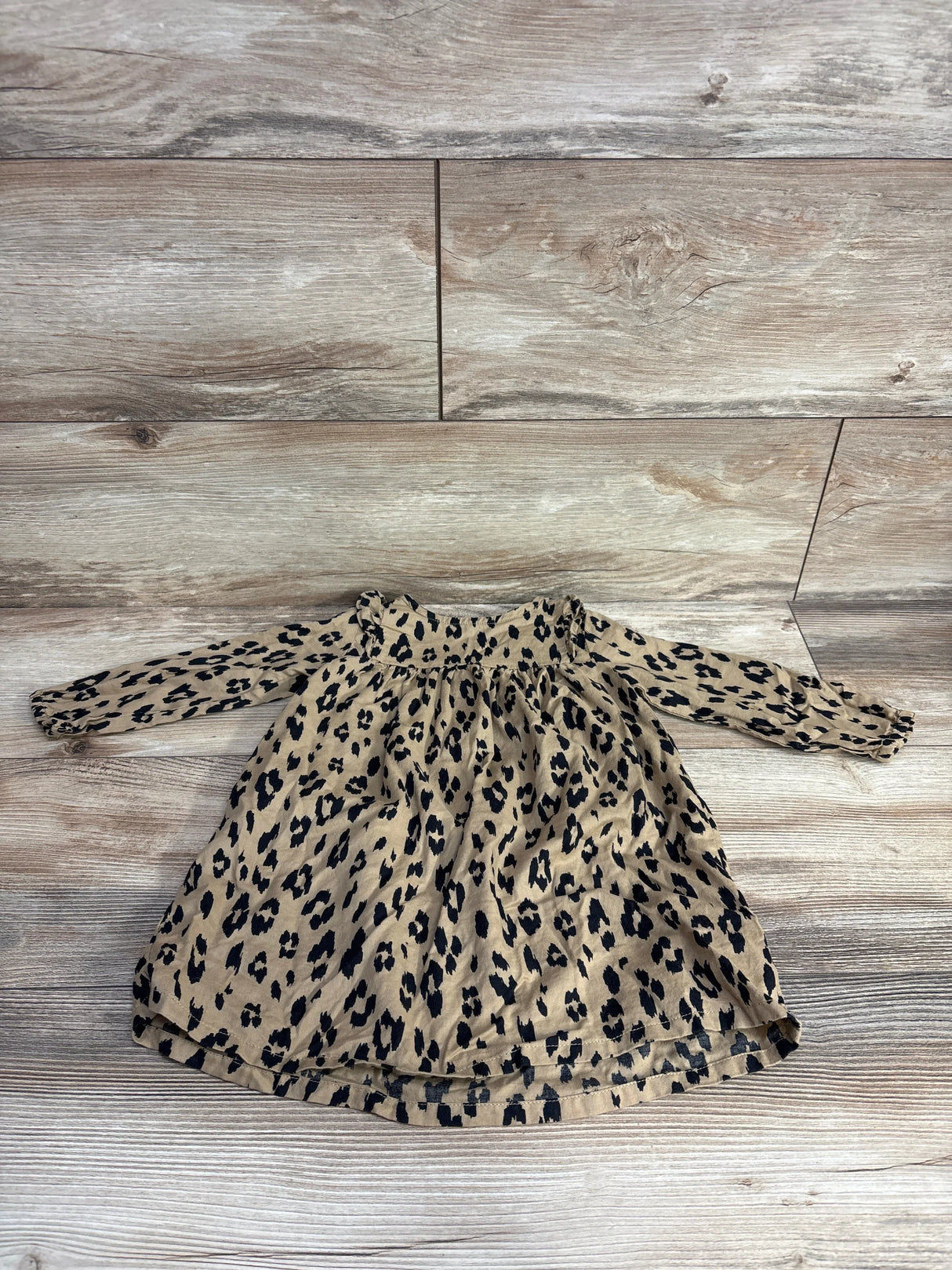 Leopard print long sleeve baby dress on wood background, gently used kids clothing