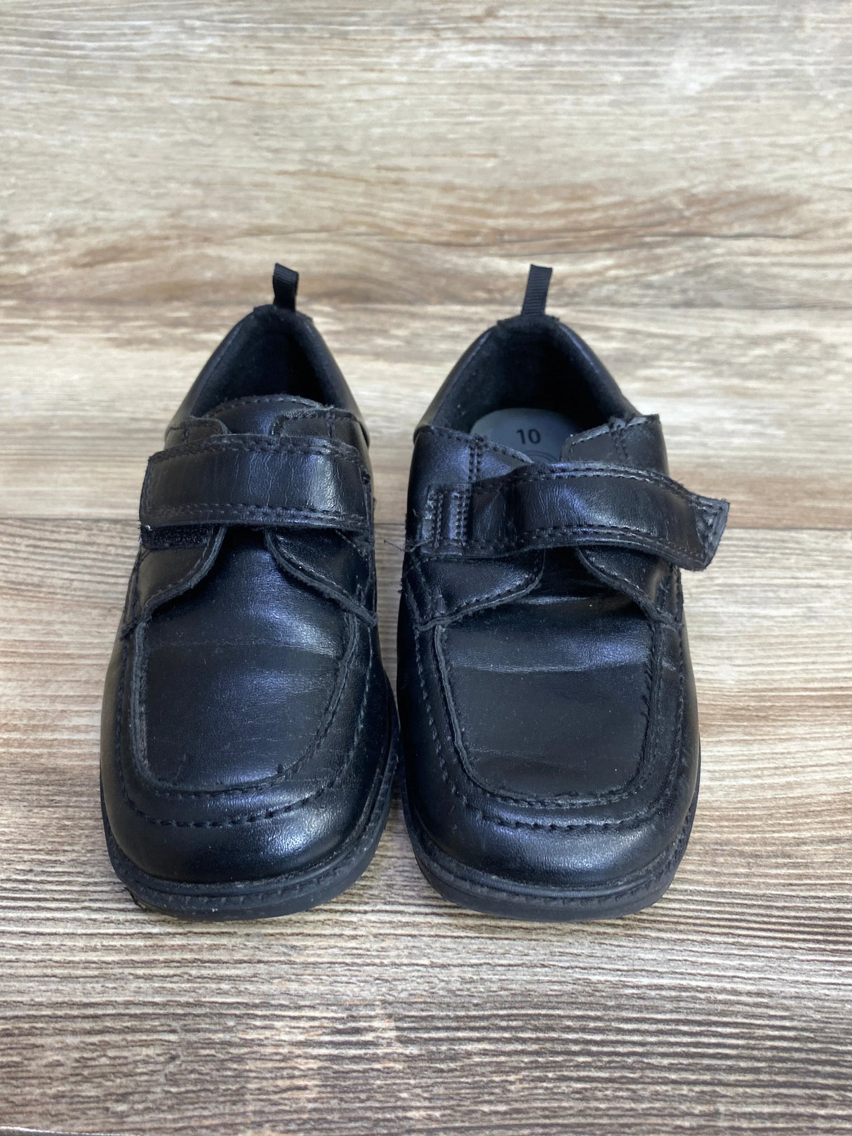 Black kids dress shoes with Velcro straps on wood background, gently used size 10