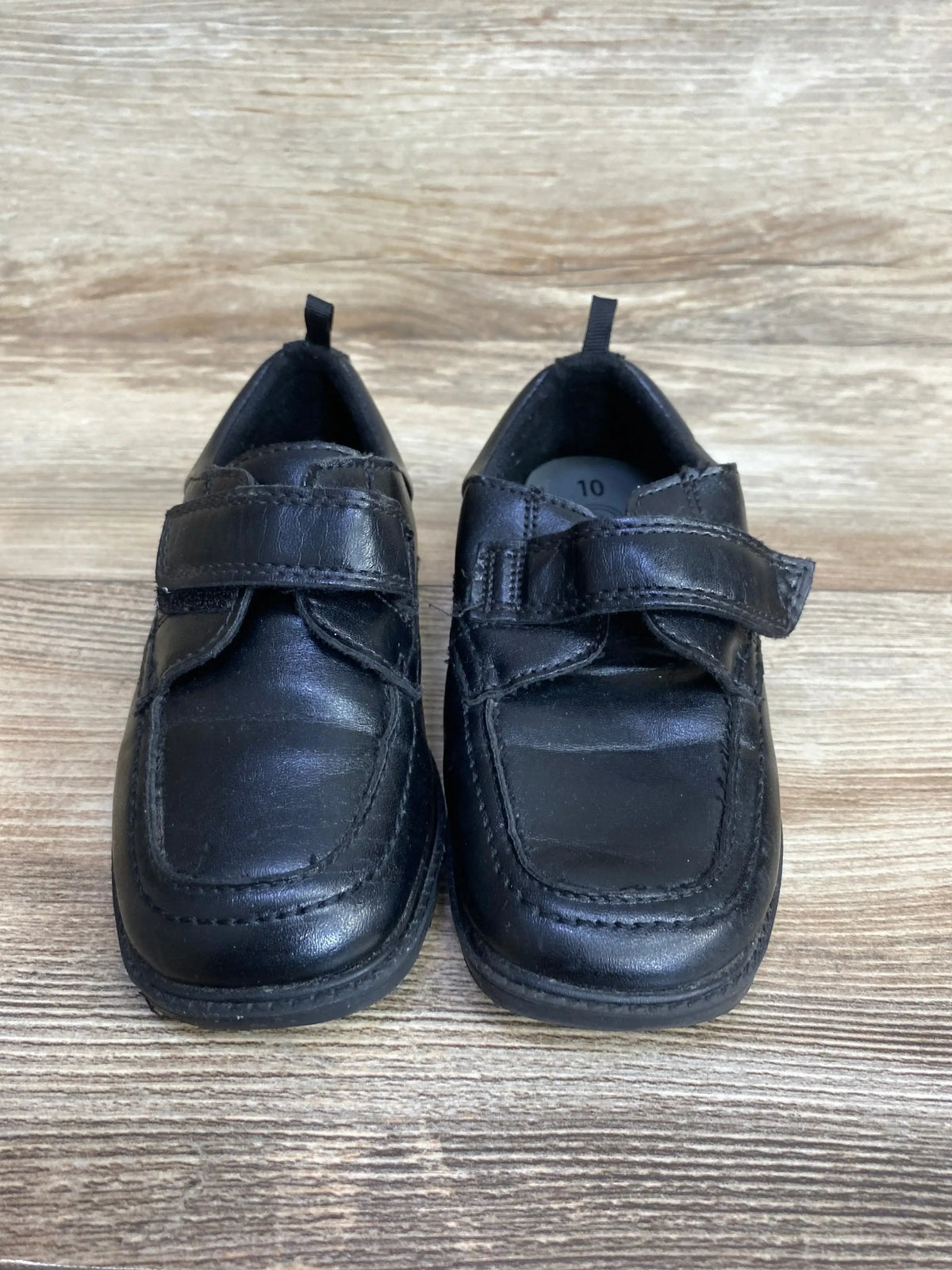 Black kids dress shoes with Velcro straps on wood background, gently used size 10
