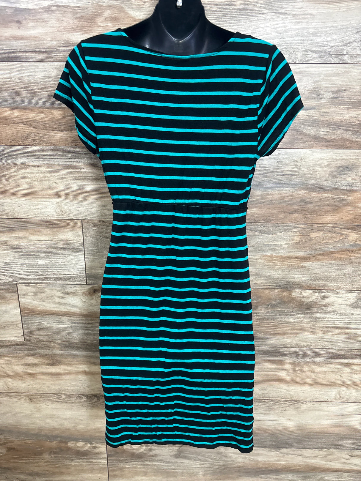 Black and teal striped short-sleeve maternity dress displayed on black mannequin against wood background