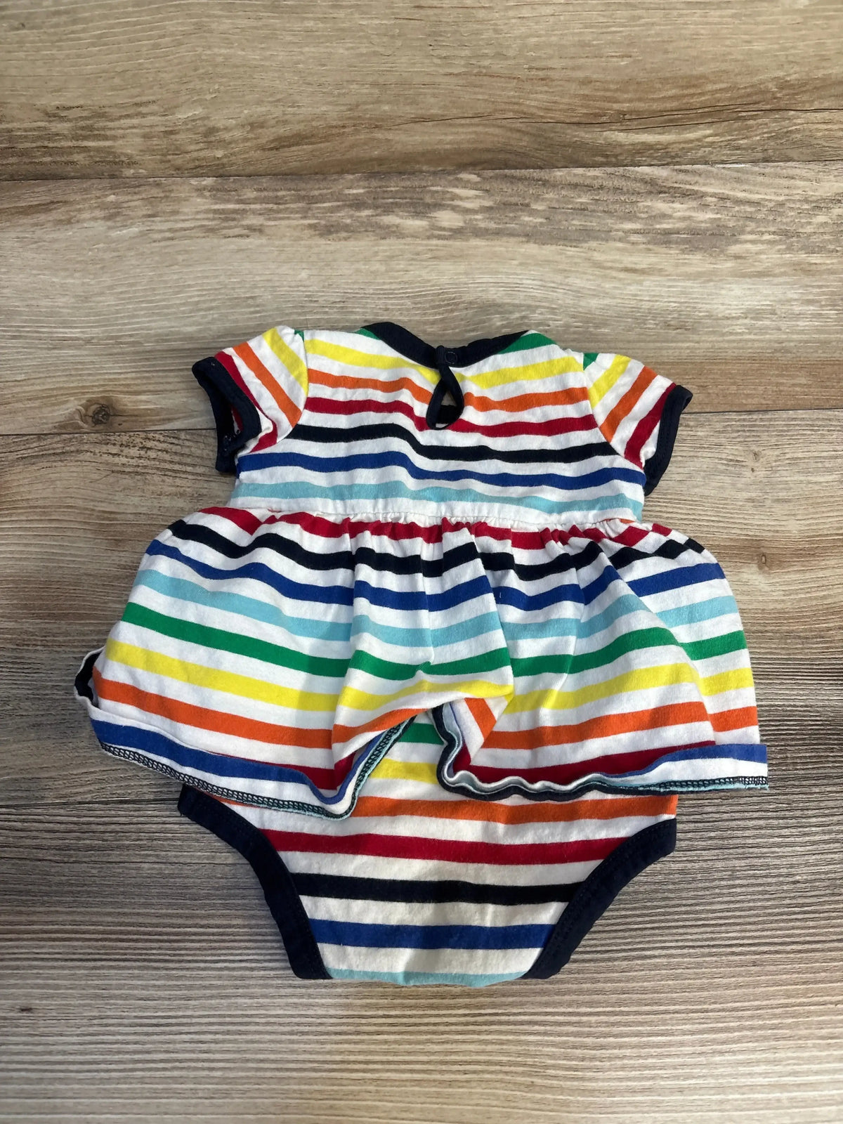 Colorful striped baby romper dress on wood background, gently used children's clothing