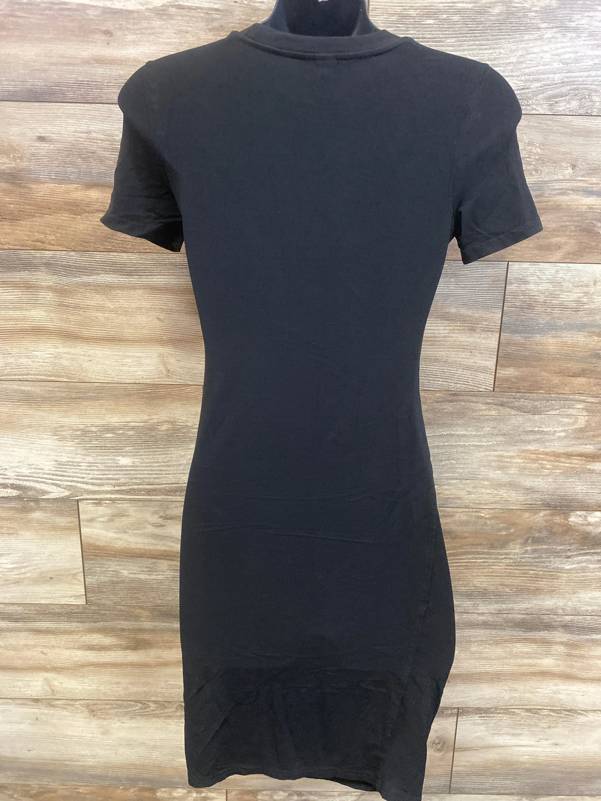 Front view of black Shein maternity dress in size small showcasing short sleeves and a round neckline with a wood-look background