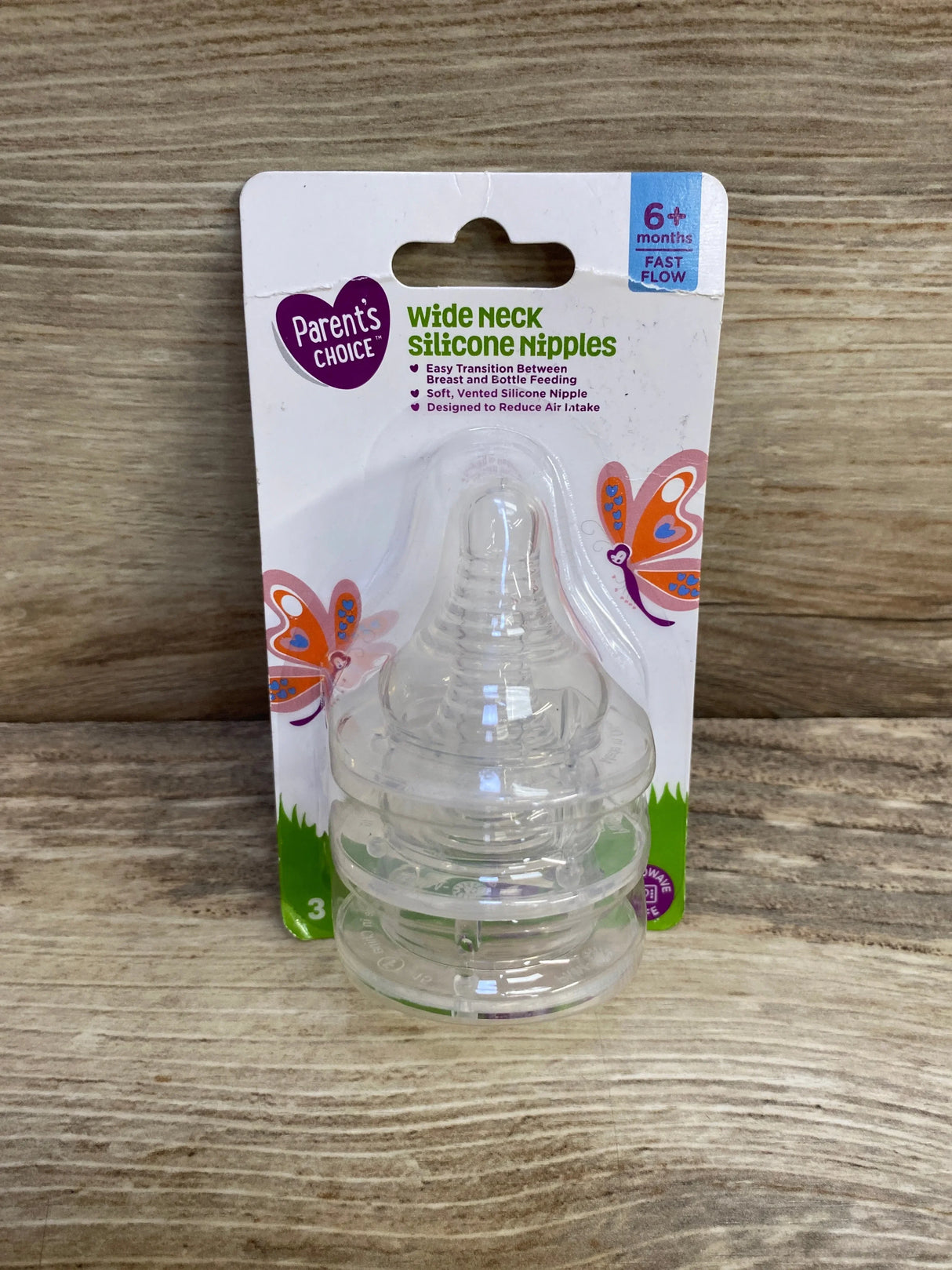 Front view of Parent's Choice 3-pack wide-neck silicone nipples with 6+ months fast-flow label on wood
