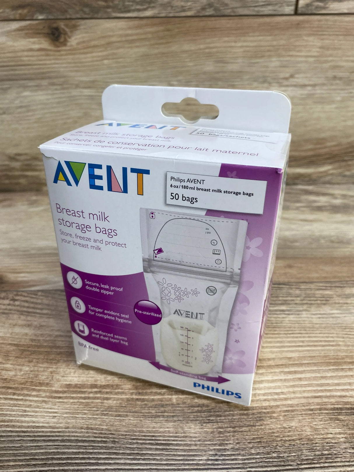 Front three-quarter view of Avent breast milk storage bags box showing 50-count 6 oz pre-sterilized bags and double-zipper, on wooden surface