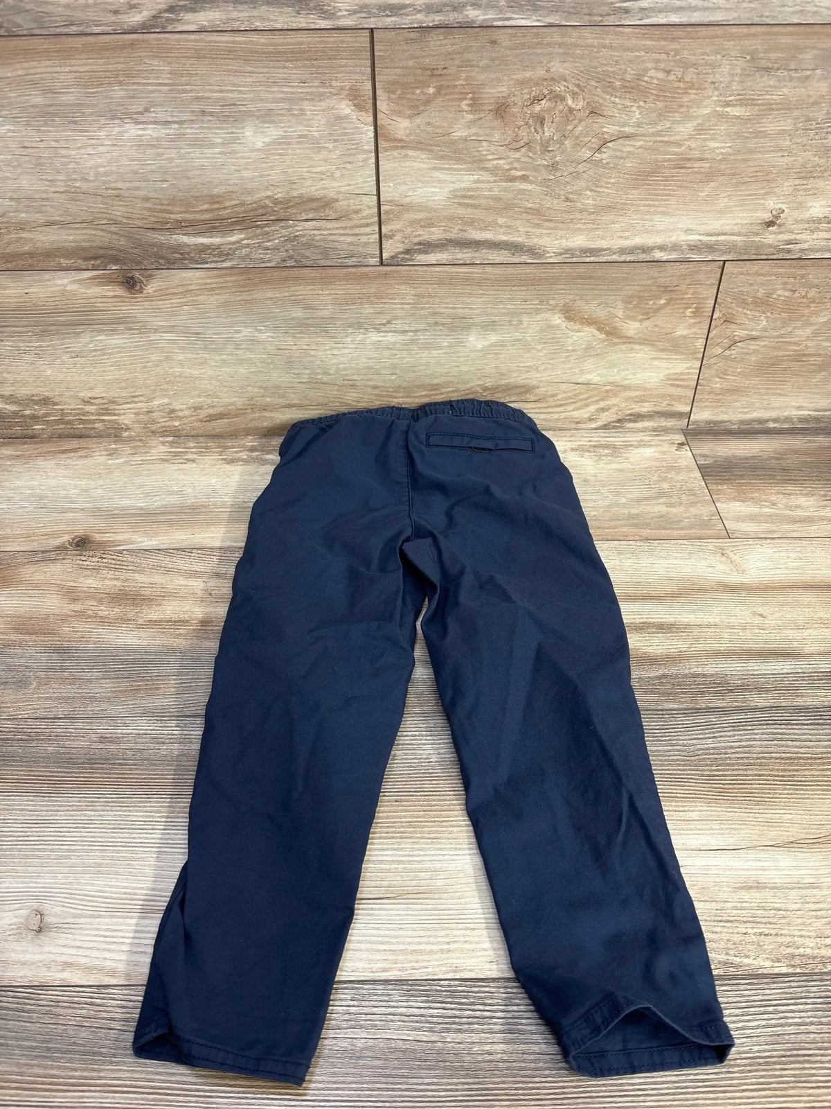 Back view of boys’ navy tech taper quick-dry pants size 5T showing elastic waistband and tapered legs on wood floor
