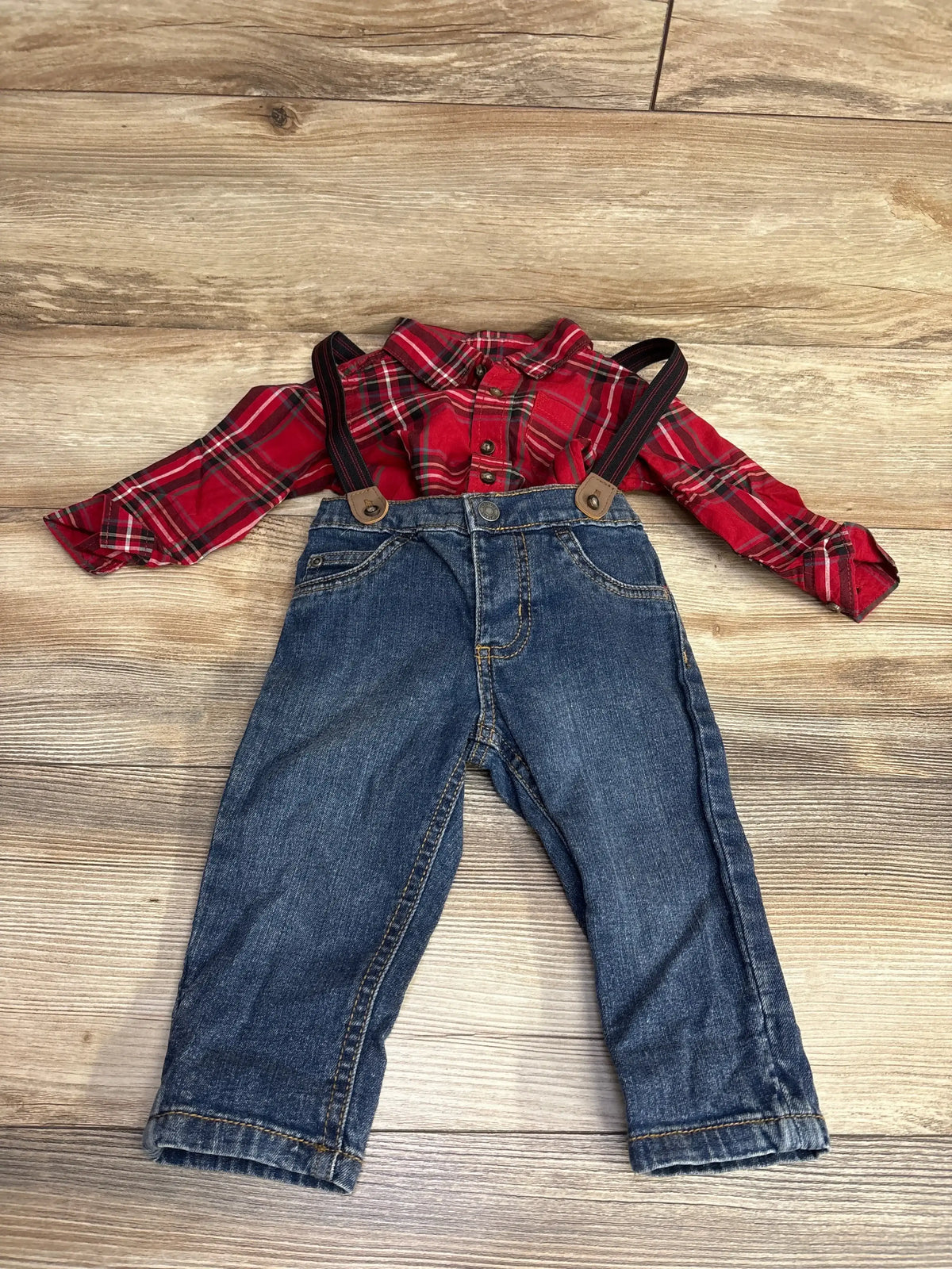 Red plaid baby shirt with denim overalls, kids clothing set on wood floor