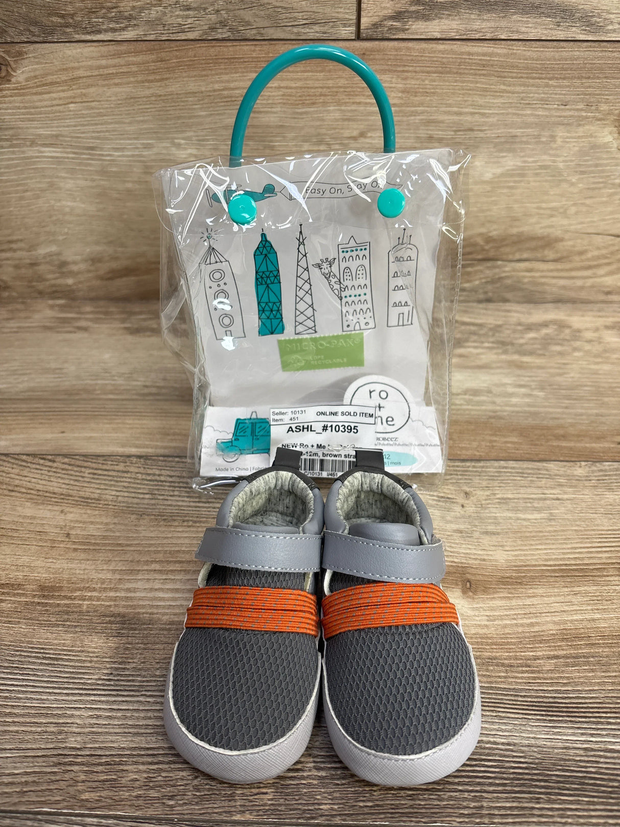 Front view of Ro + Me by Robeez grey mesh baby sneakers size 3/4 showing orange elastic band and hook-and-loop strap