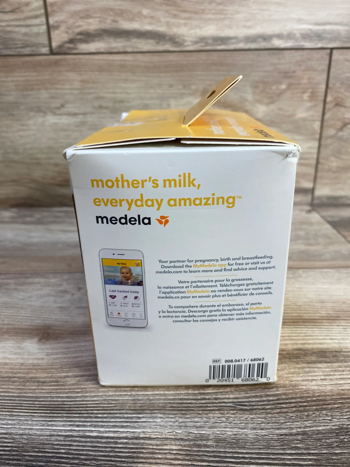 Front of Medela breast milk storage bags box (100 ct, 6 oz) showing slogan ‘mother’s milk, everyday amazing’ on wood table