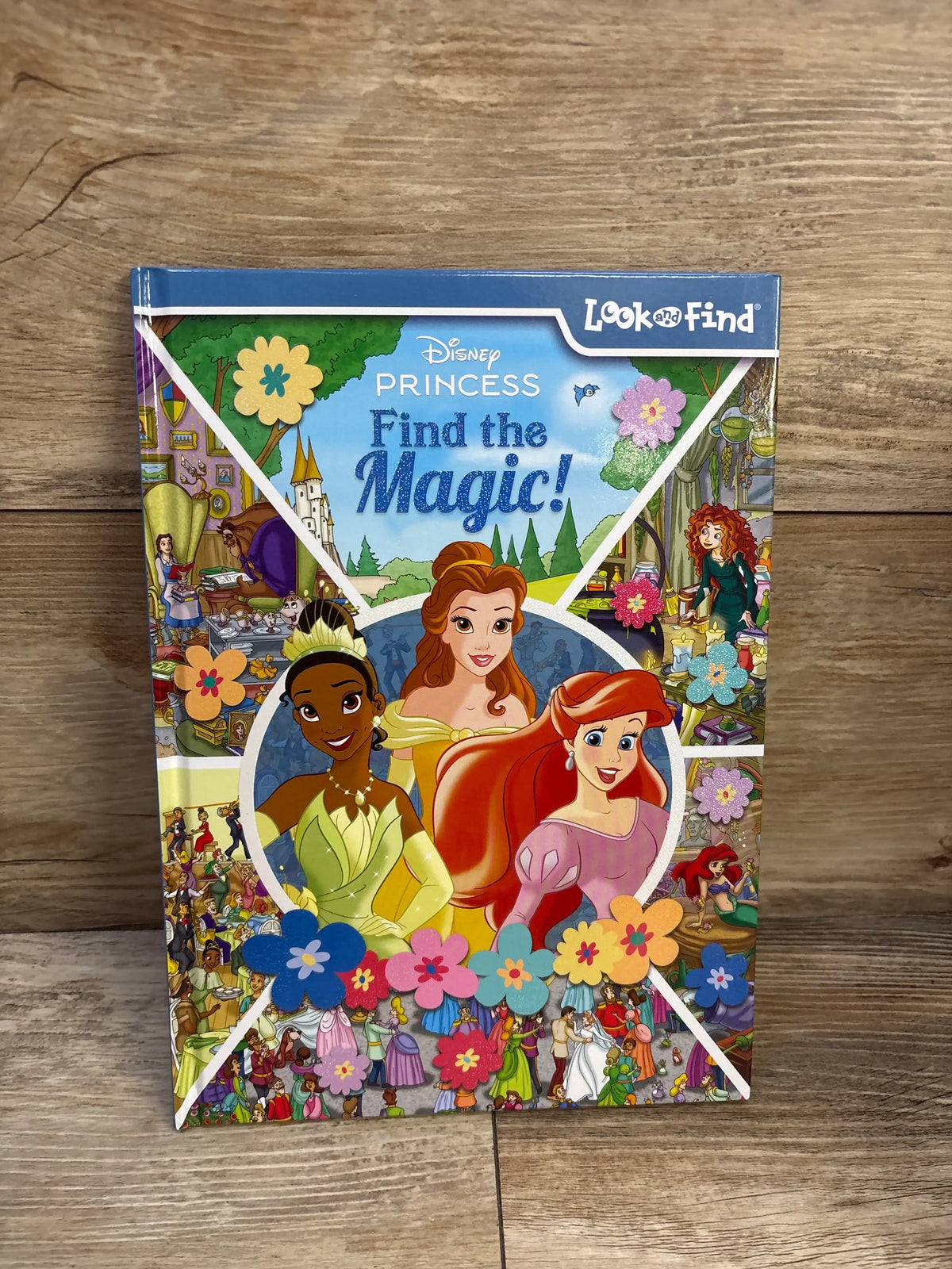 Front cover of Disney Princess Find the Magic! hardcover activity book featuring Belle, Tiana, and Ariel amid search-and-find scenes