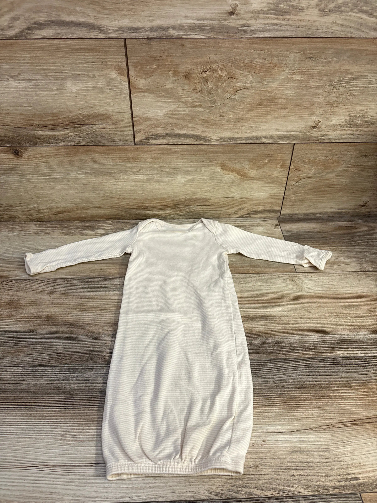Top view of Carter’s beige striped sleep gown showcasing long sleeves and a gathered hem on a wood floor