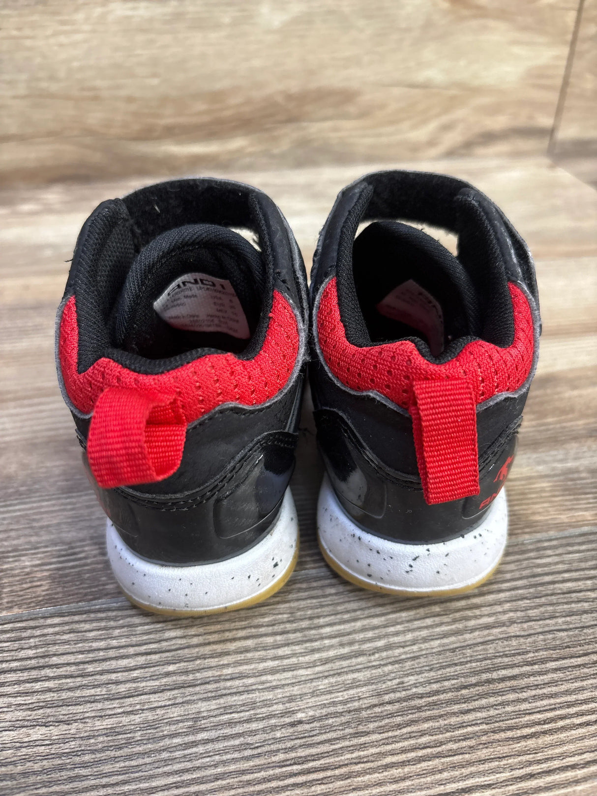 Rear view of AND1 Lace-Up Basketball Sneakers (toddler size 8C) showcasing red padded collar and heel pull tab with speckled white midsole on wood floor