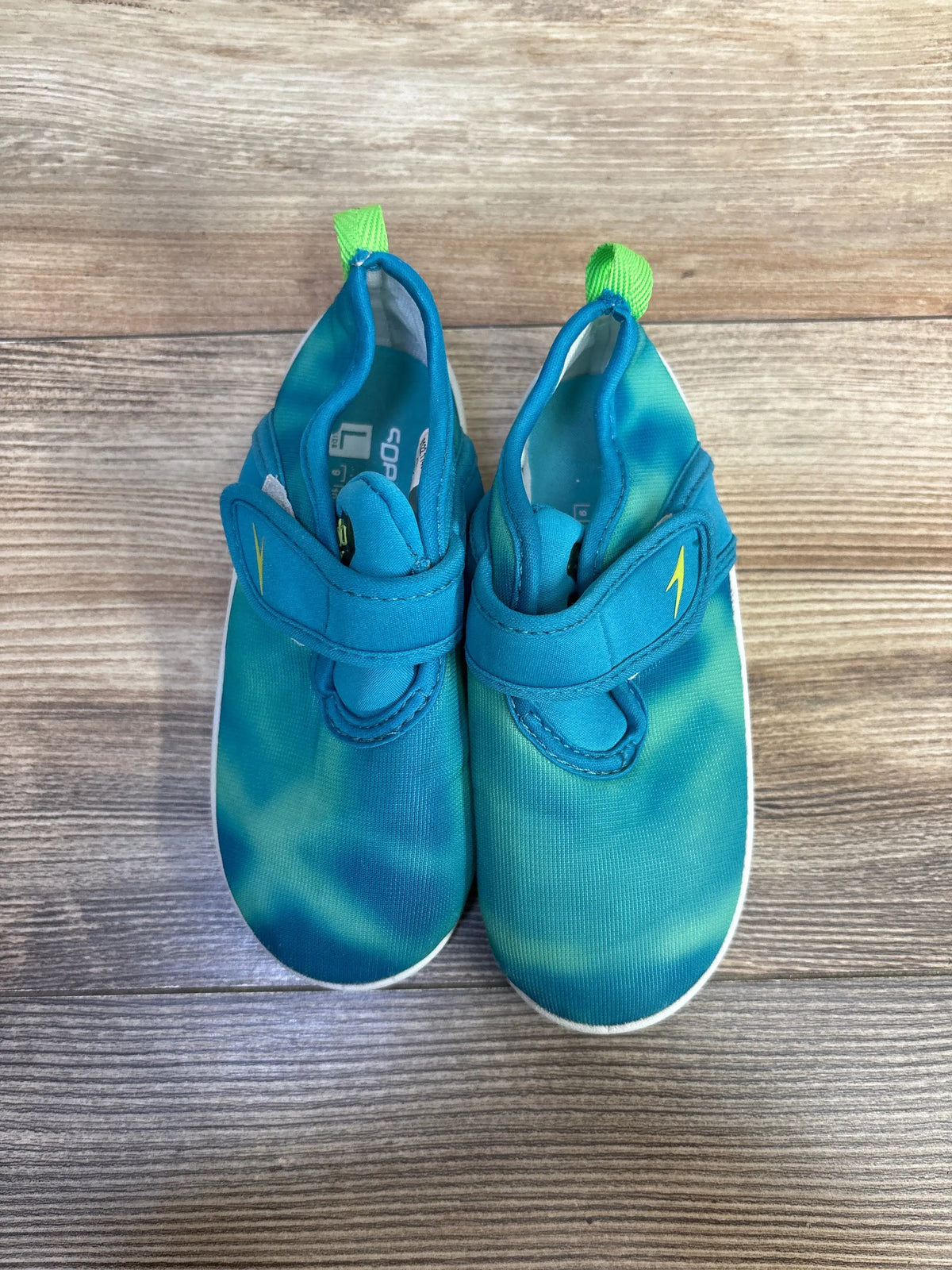 Top view of seafoam Speedo Shore Explorer water shoes, size 9/10C, with easy closures and pull tabs on wood grain