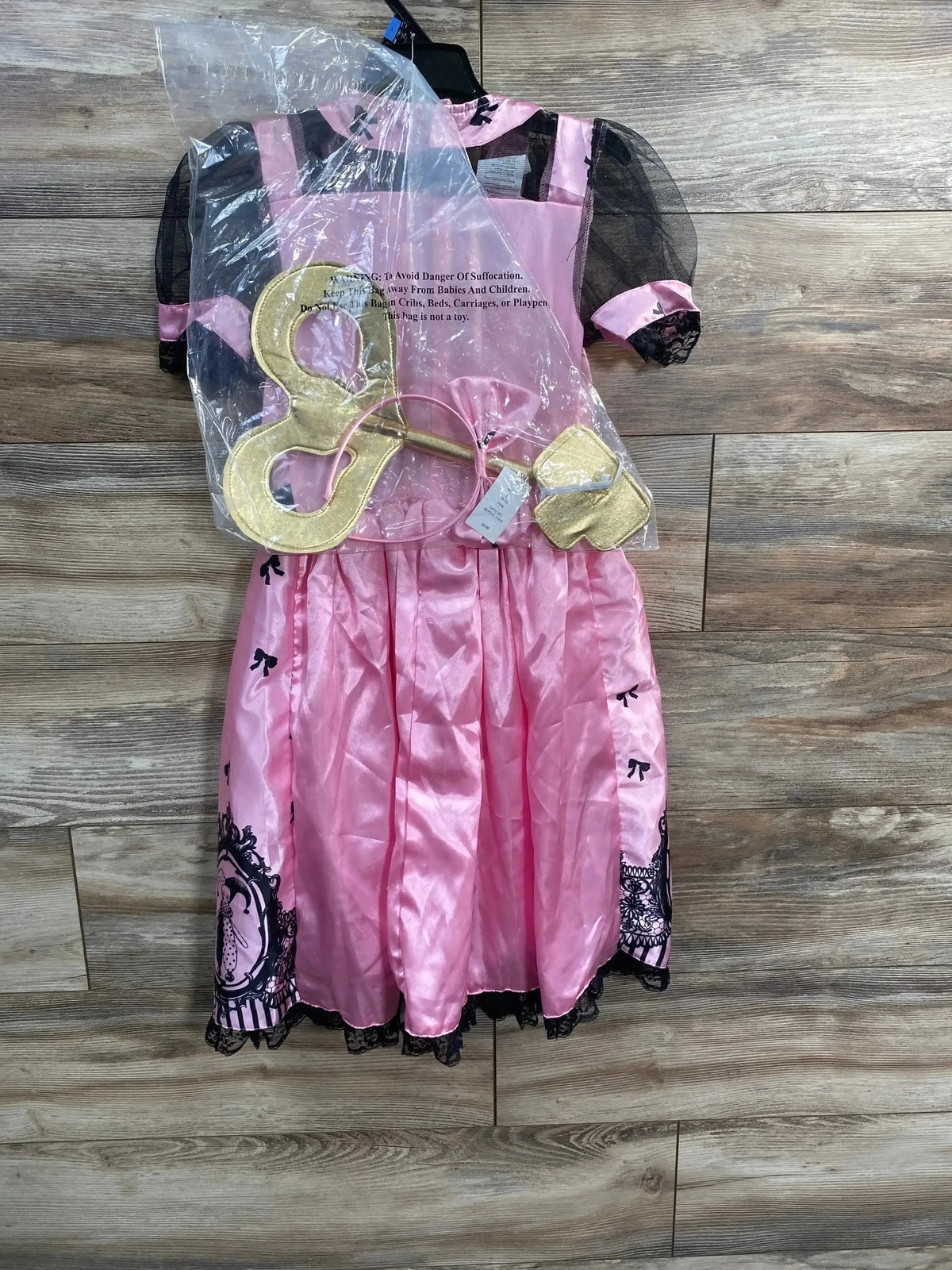 Front of Hyde and Eek wind up doll costume, pink satin with black lace, gold wind up key and purse on wood floor