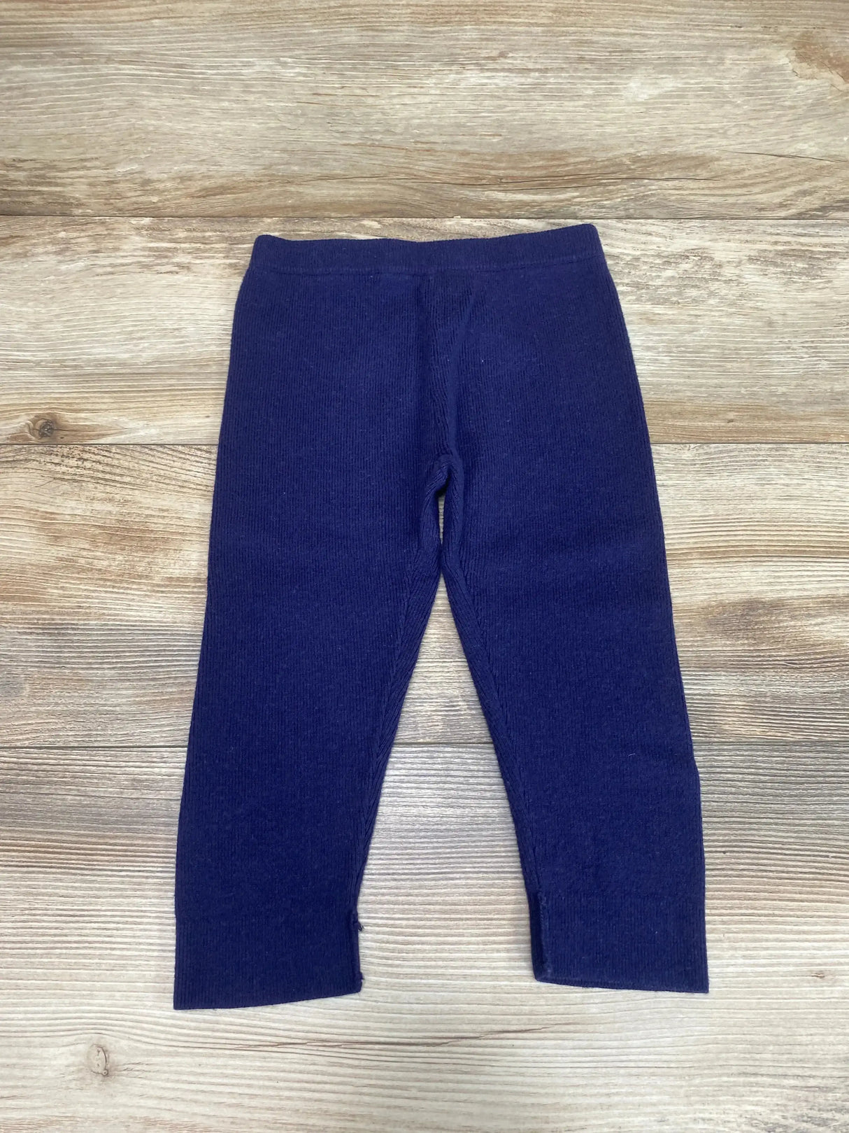 Flat lay of Janie and Jack navy knit sweater pants (18-24 months) showing ribbed ankles on wood background