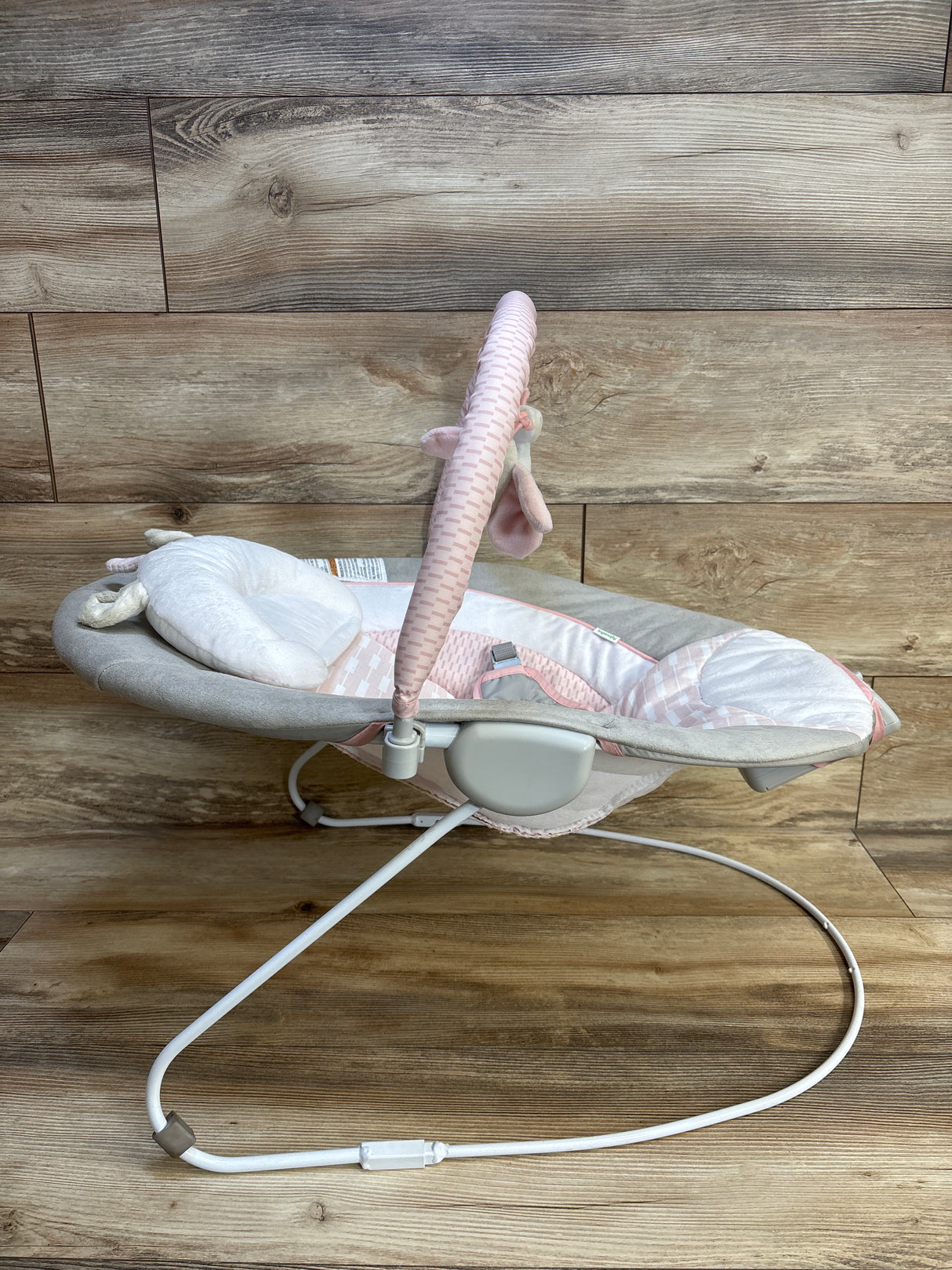 Pink and gray baby swing with plush toy, ideal for infant comfort and nursery decor