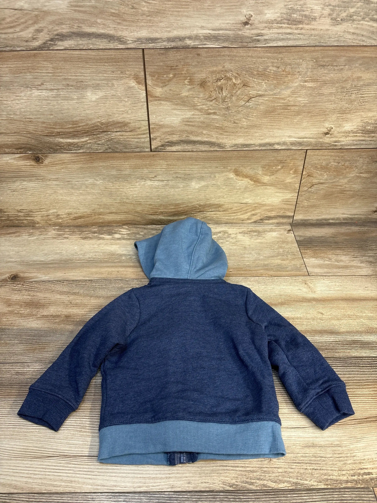 Back view of Cat & Jack full-zip toddler hoodie in navy with light-blue hood and ribbed hem on wood floor