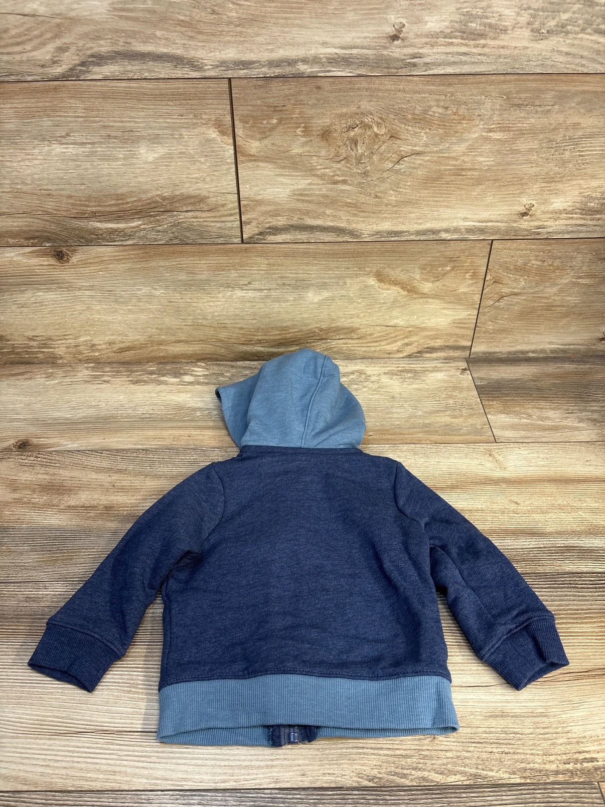 Back view of Cat & Jack full-zip toddler hoodie in navy with light-blue hood and ribbed hem on wood floor