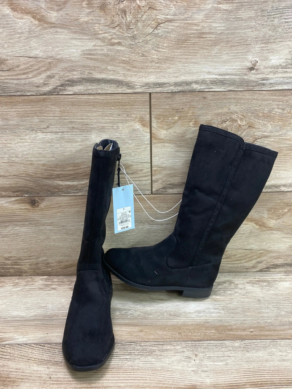 Side view of Cat and Jack Mylah tall riding boots in black suede with hangtag attached on wood plank background