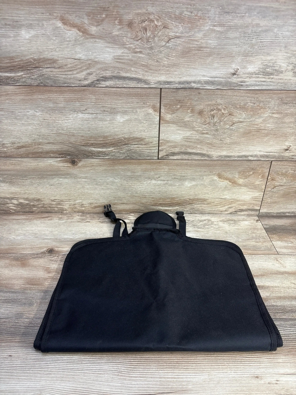 Front view of Nuby x Safe in the Seat car seat protector showcasing headrest strap and adjustable buckles on wood plank background
