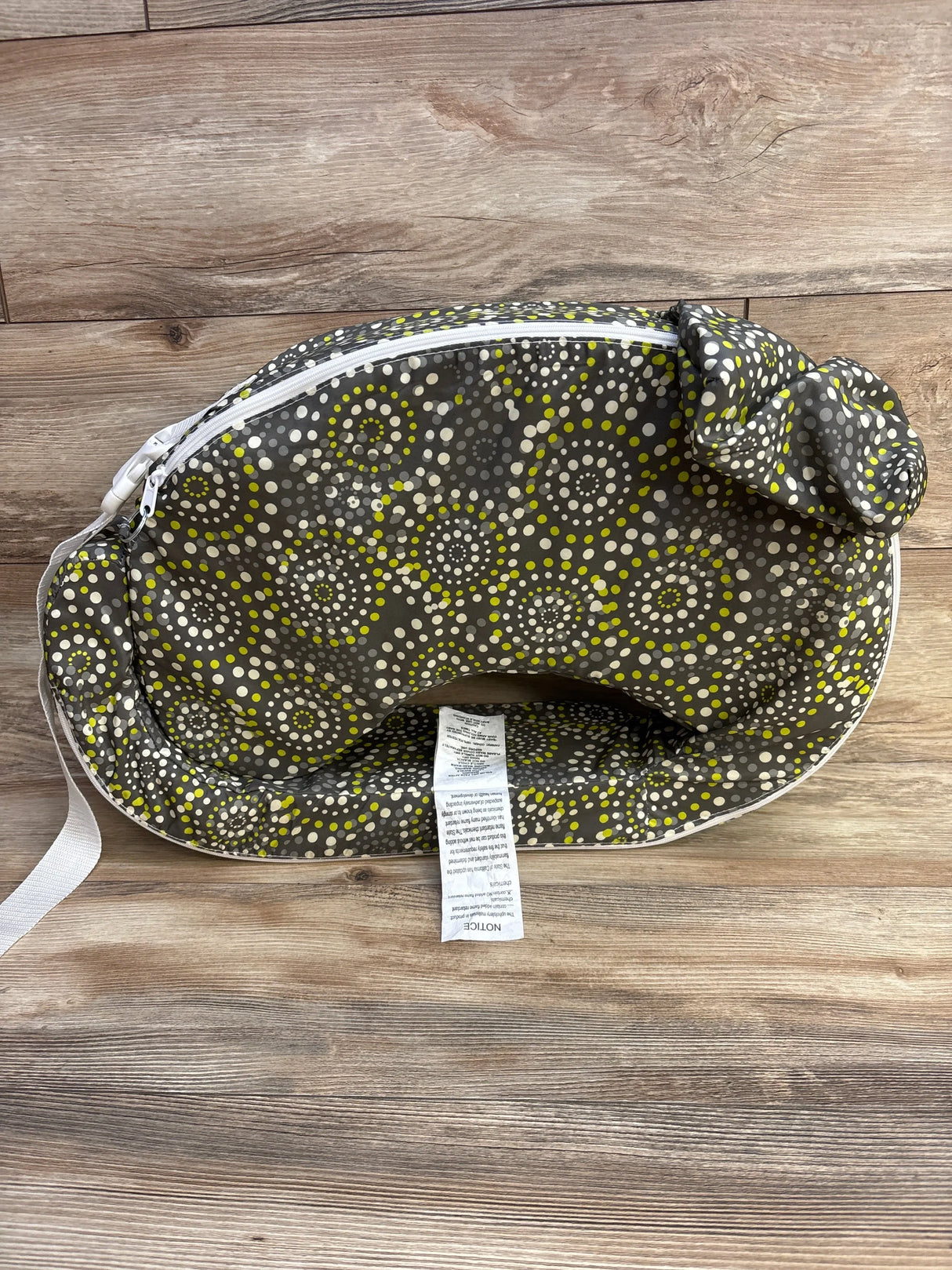 Top-down view of My Brest Friend nursing pillow showcasing Fireworks dot print, white zipper and attached head cushion on wood background