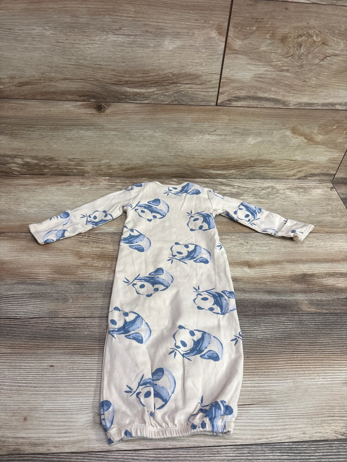 Ivory Carter's baby sleep gown featuring a blue panda print on a wood background.