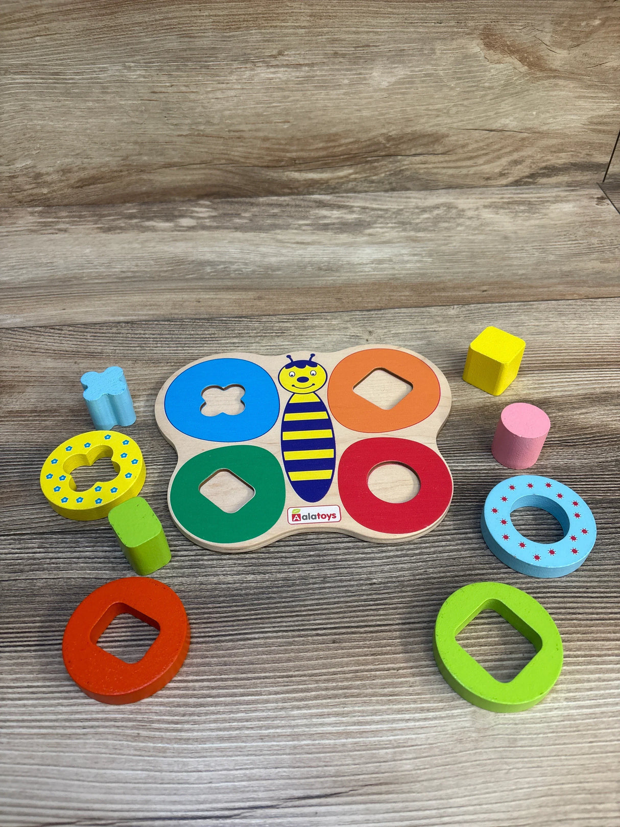 Colorful wooden shape sorter puzzle toy for kids with butterfly design on wood background